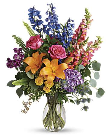 Colors Of The Rainbow Bouquet - A rainbow of beauty for any occasion. Purple hydrangea, pink roses and orange lilies positively pop in this bright bouquet, featuring all the colors of the rainbow. This colorful bouquet includes purple hydrangea, pink roses, yellow spray roses, orange asiatic lilies, purple alstroemeria, blue delphinium, pink snapdragons, blue eryngium, huckleberry, oregonia, Israeli ruscus, sword fern, silver dollar eucalyptus, seeded eucalyptus, and lemon leaf. Delivered in a jordan vase. Orientation: All-Around