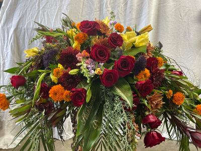 Large mixed bouquet of red roses, yellow blooms, and orange flowers