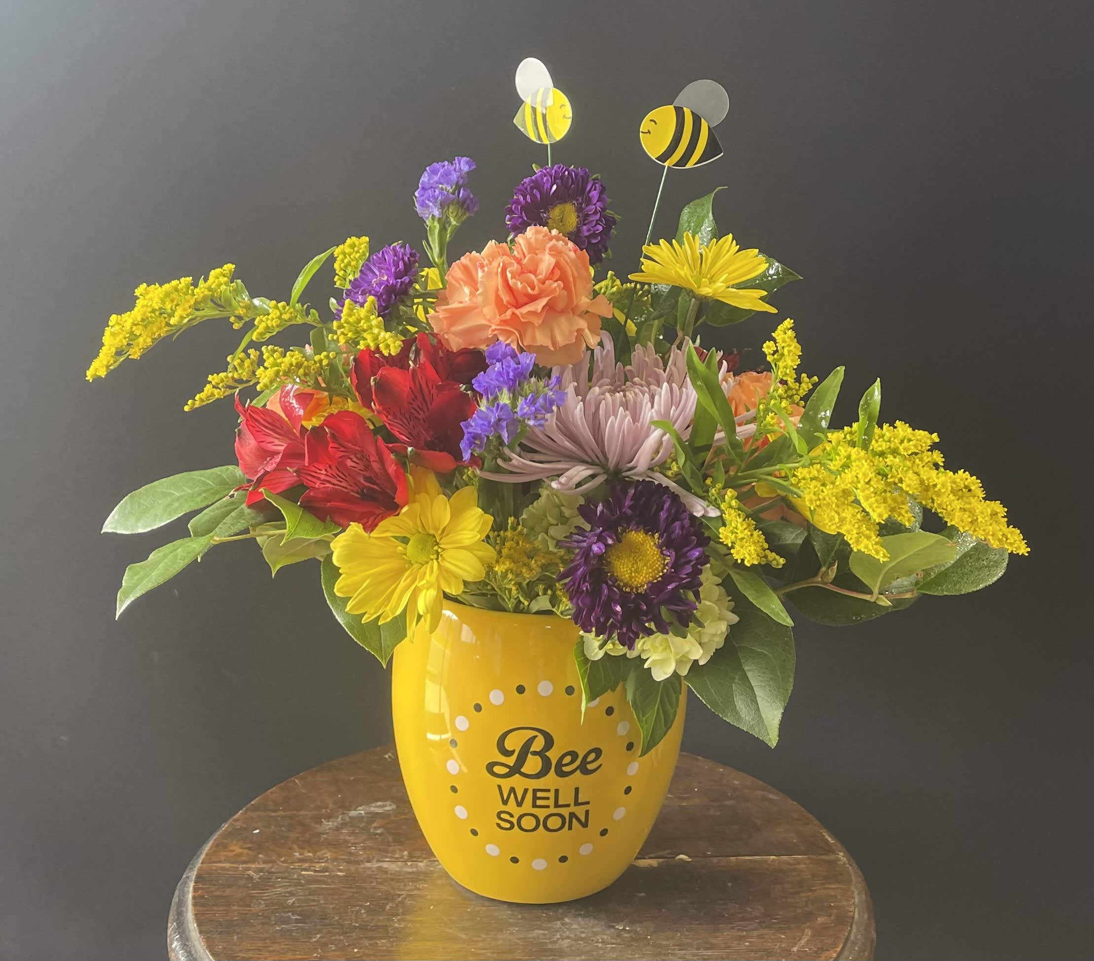 Colorful bouquet in a yellow "Bee Well Soon" mug with bee picks