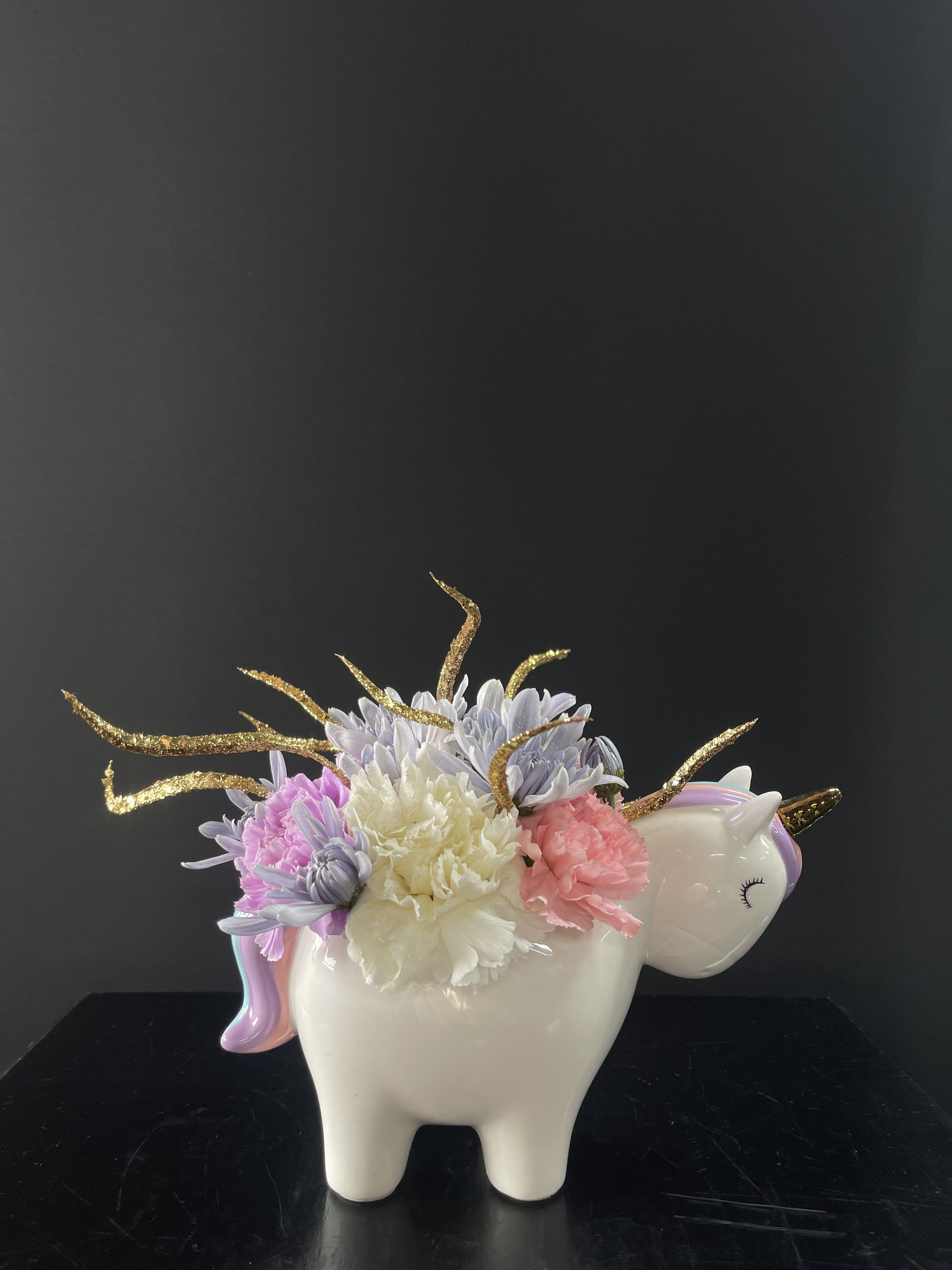 Unicorn-shaped vase with pastel flowers and gold glitter accents