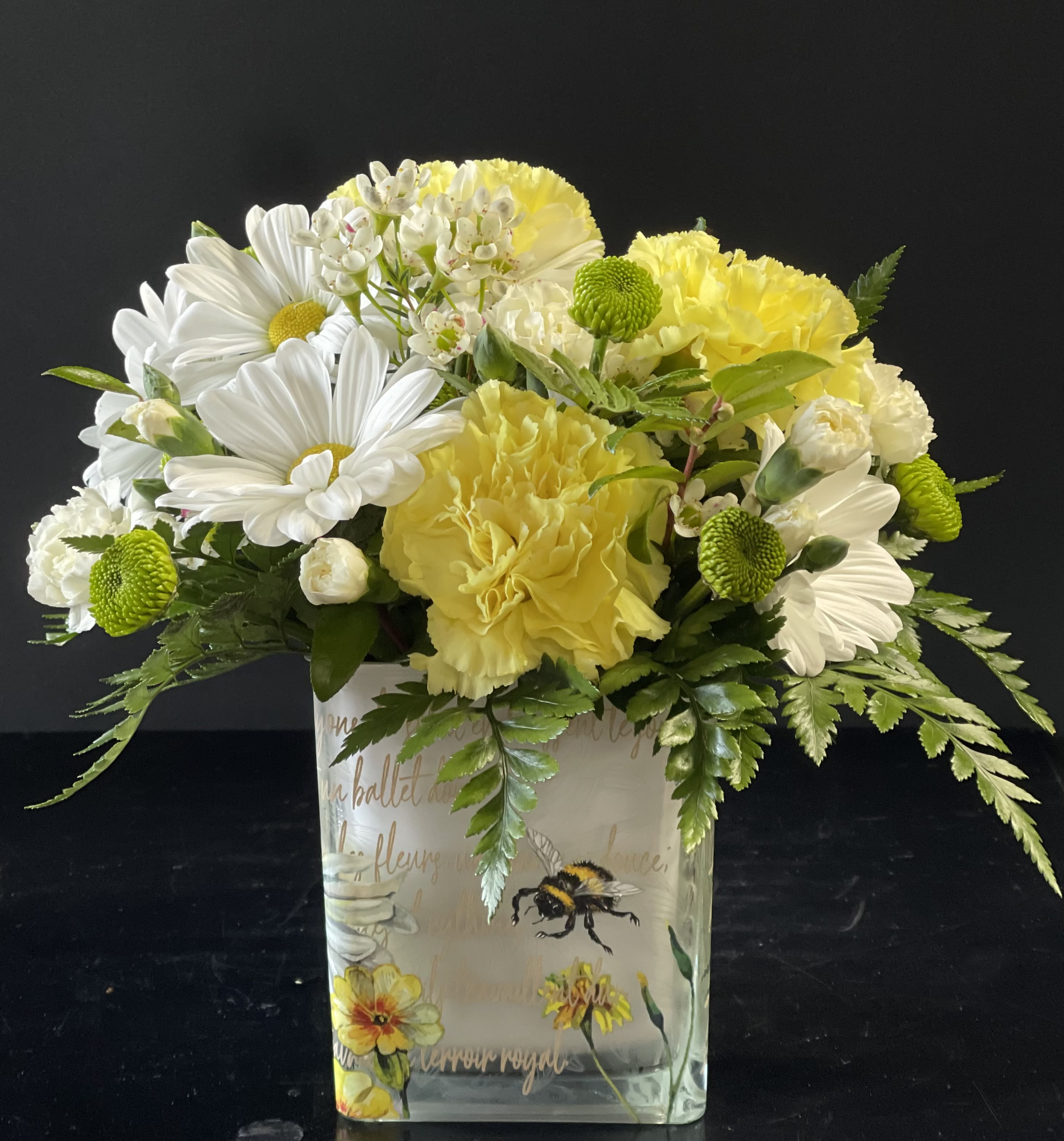 Yellow and white bouquet in a decorated glass vase