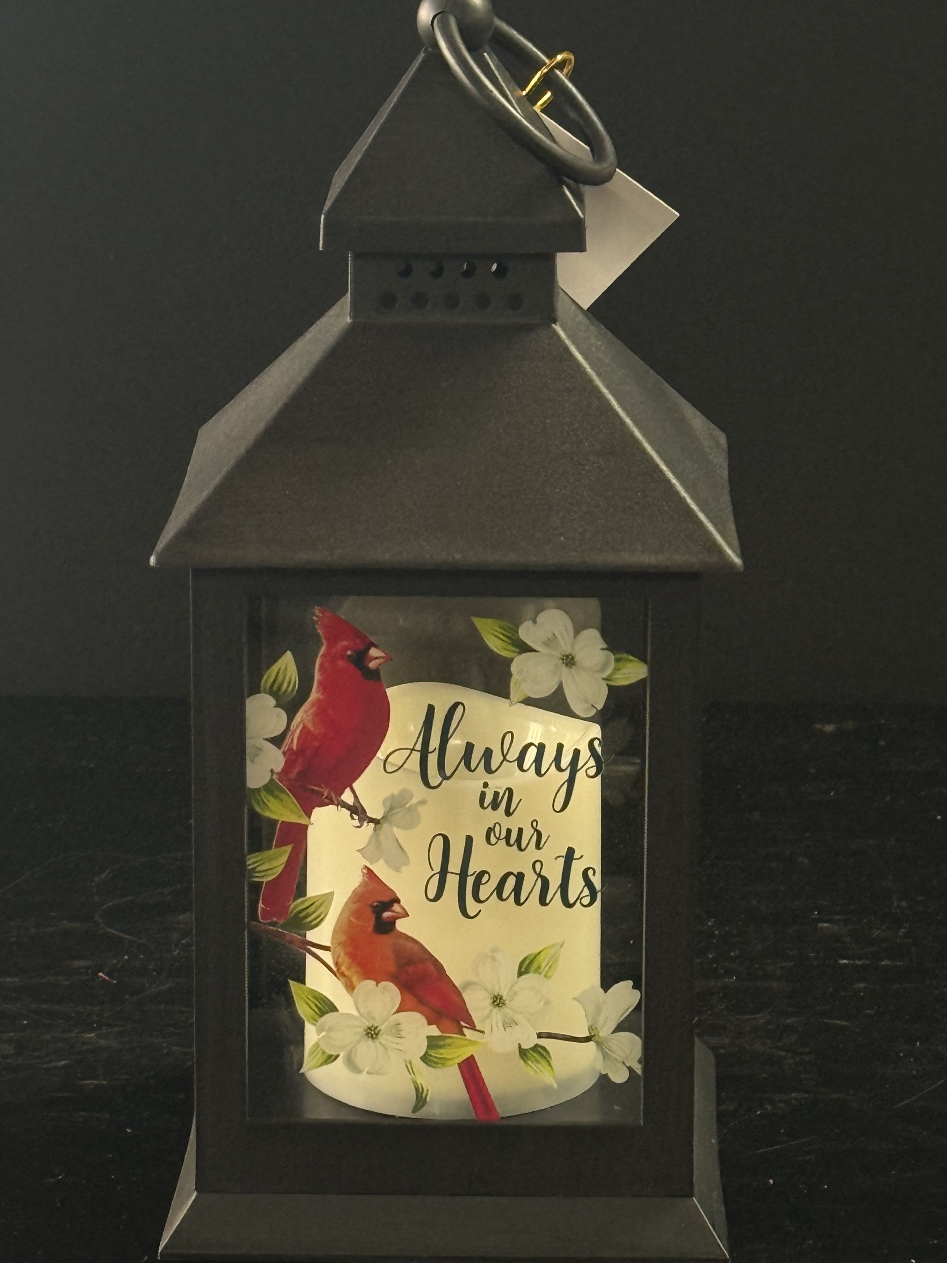 Black lantern with cardinals and flowers reading "Always in our Hearts"