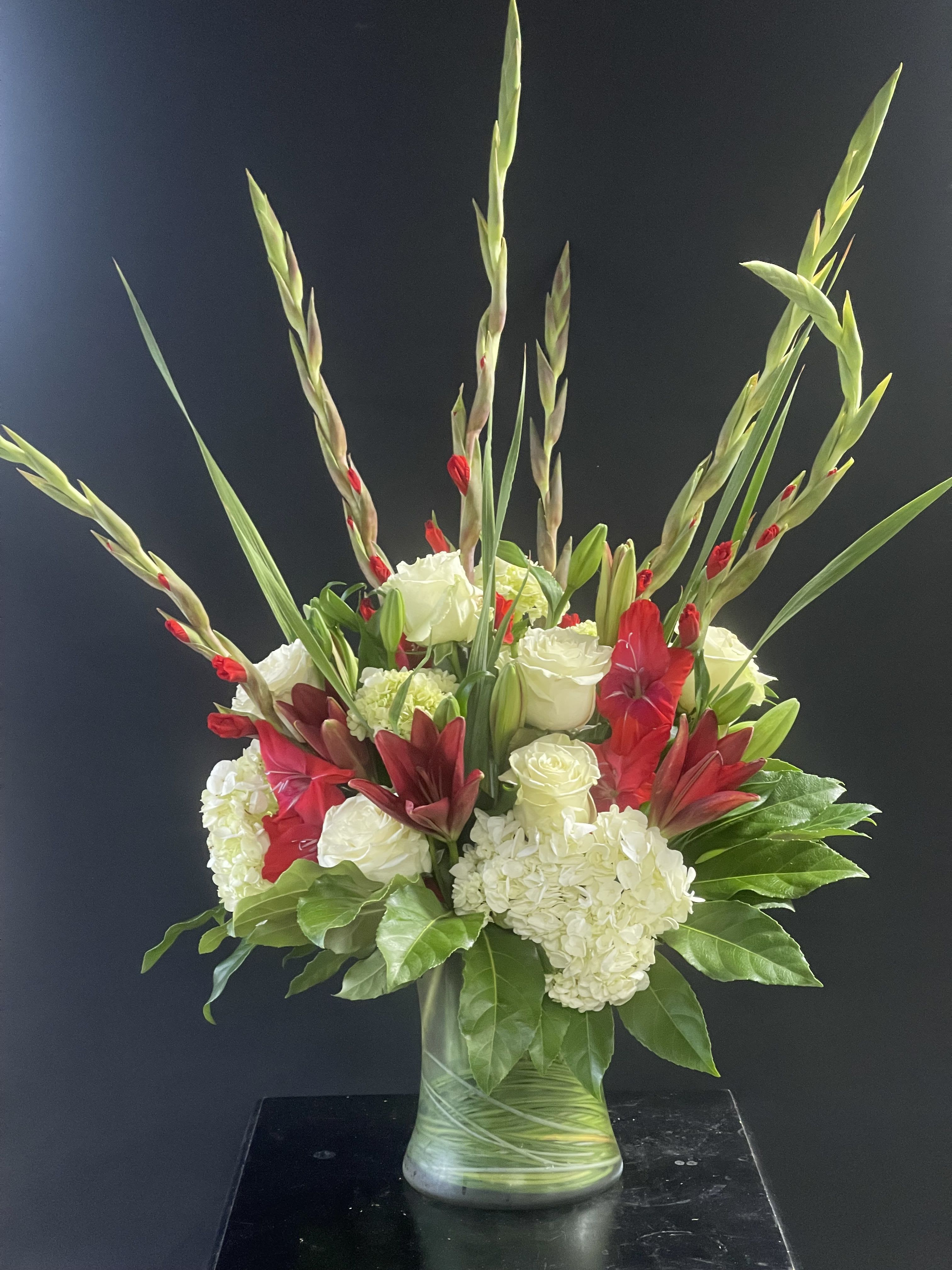 Red and white floral arrangement in a glass vase