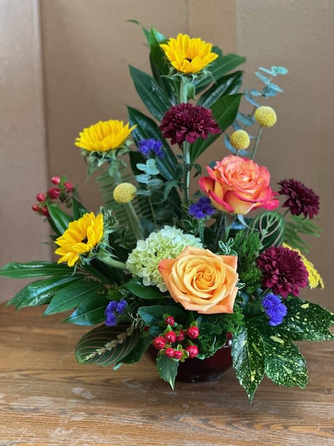 Mixed bouquet with roses, chrysanthemums, and hydrangea in a low vase