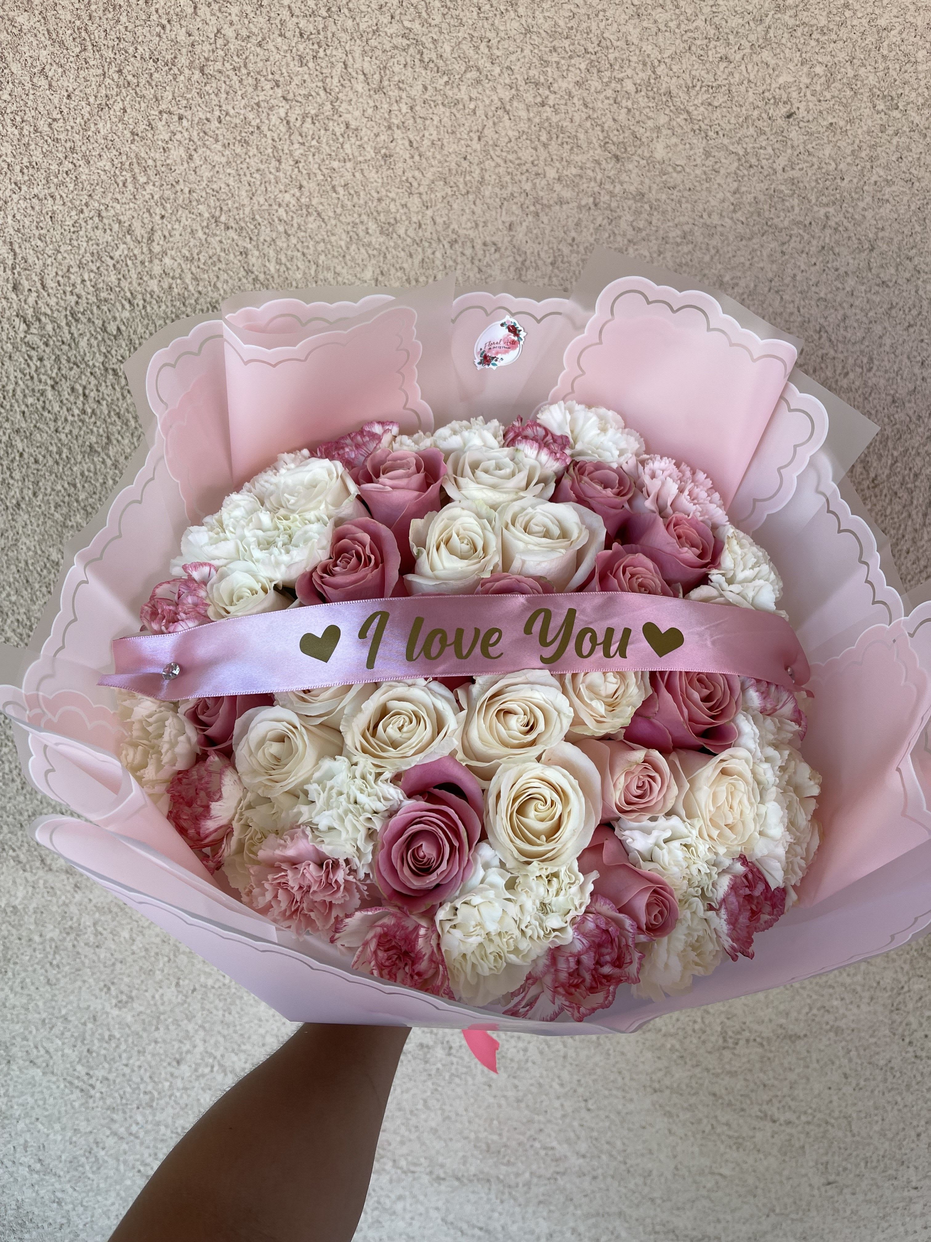 Pink and white rose bouquet with a satin "I love You" ribbon