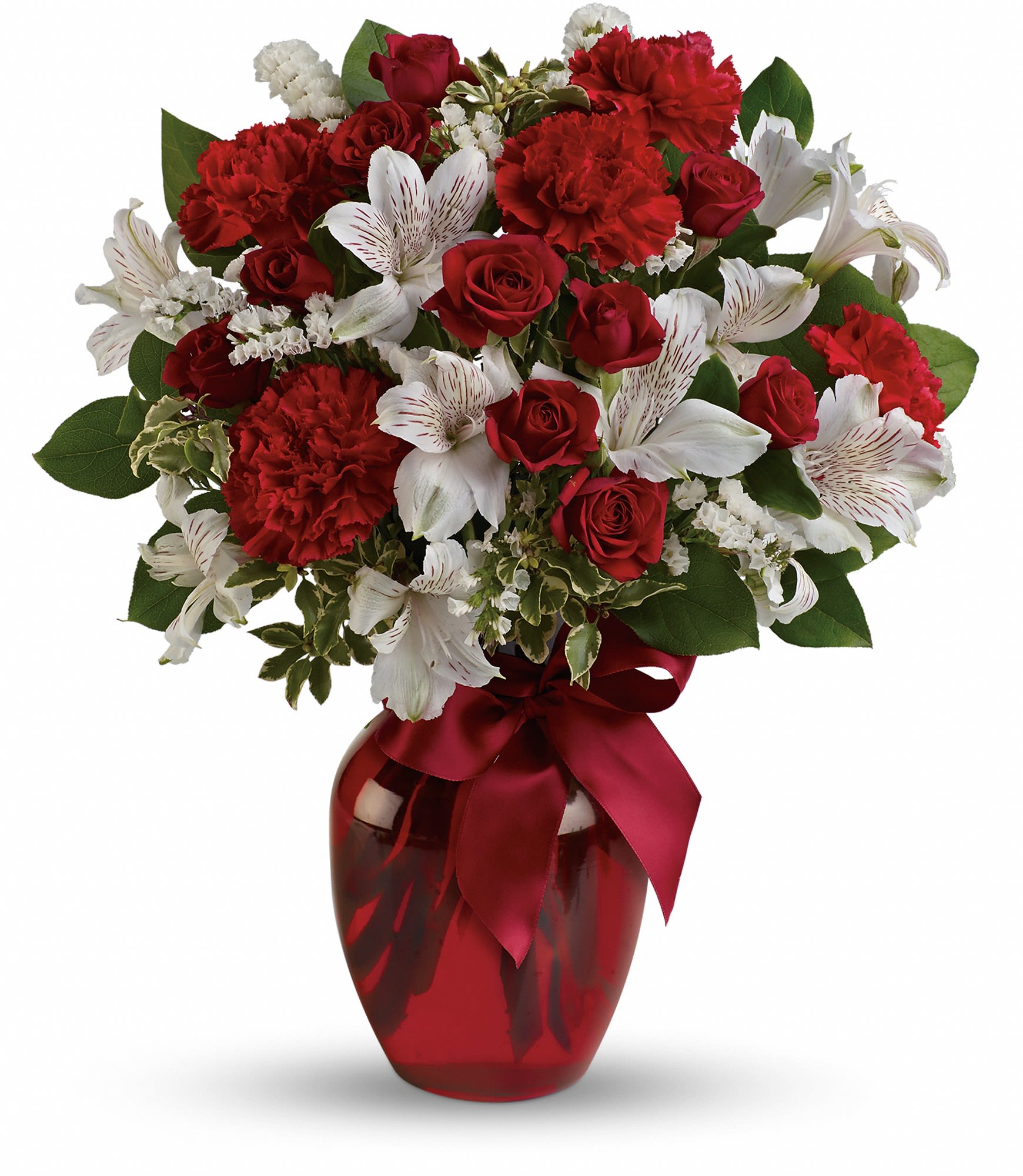 Red roses and white lilies in a red glass vase with a ribbon