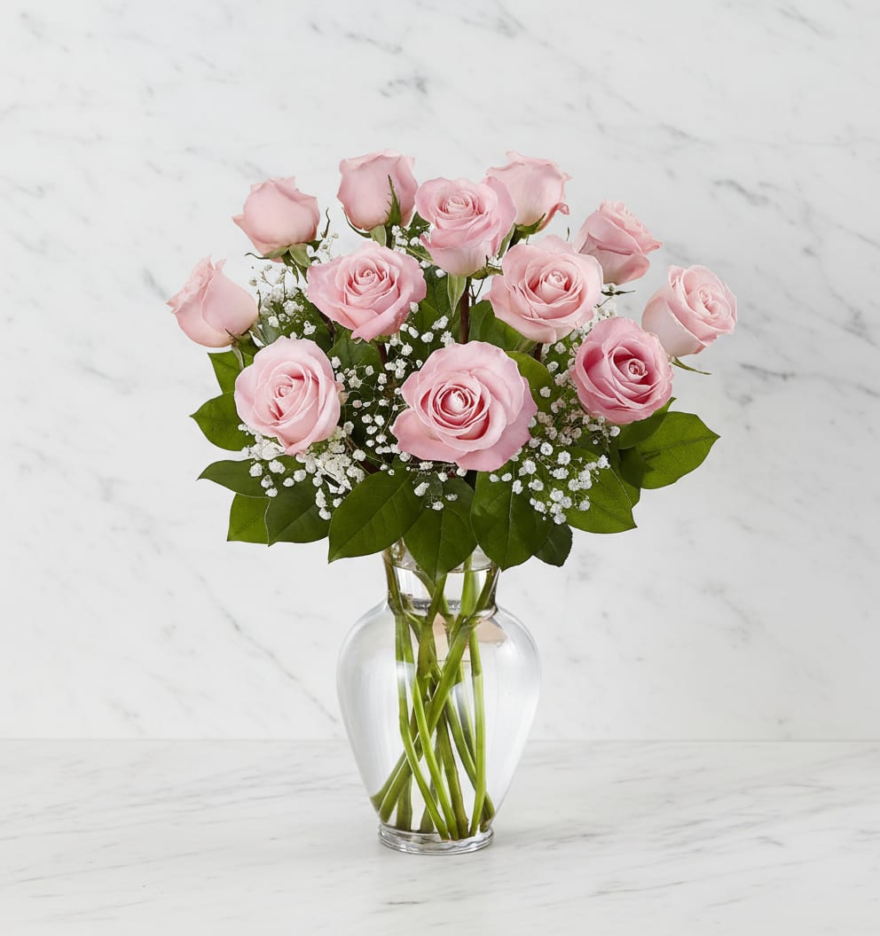 Pink roses arranged in a clear glass vase with baby's breath