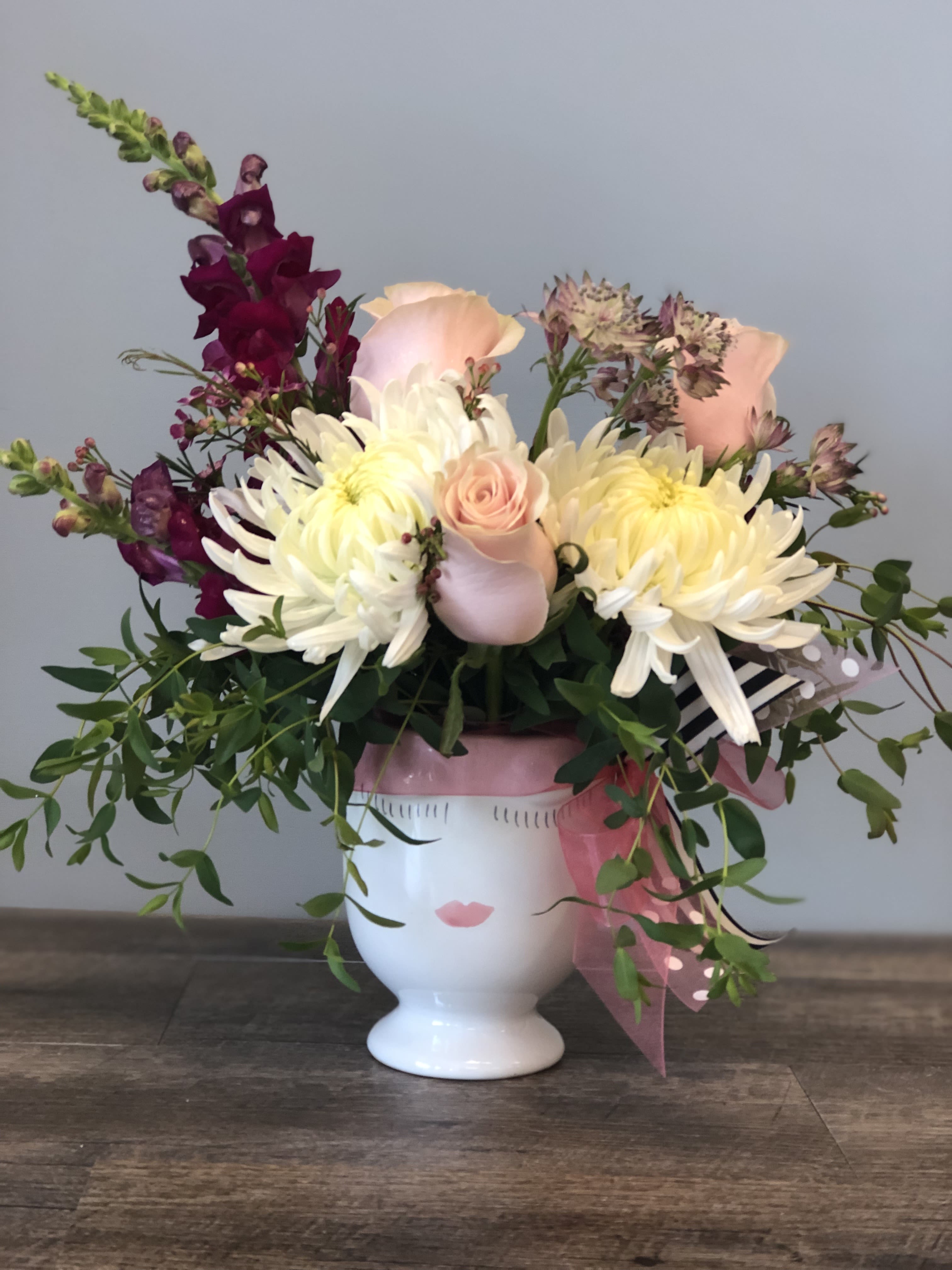Bouquet of white and blush flowers in a white face vase