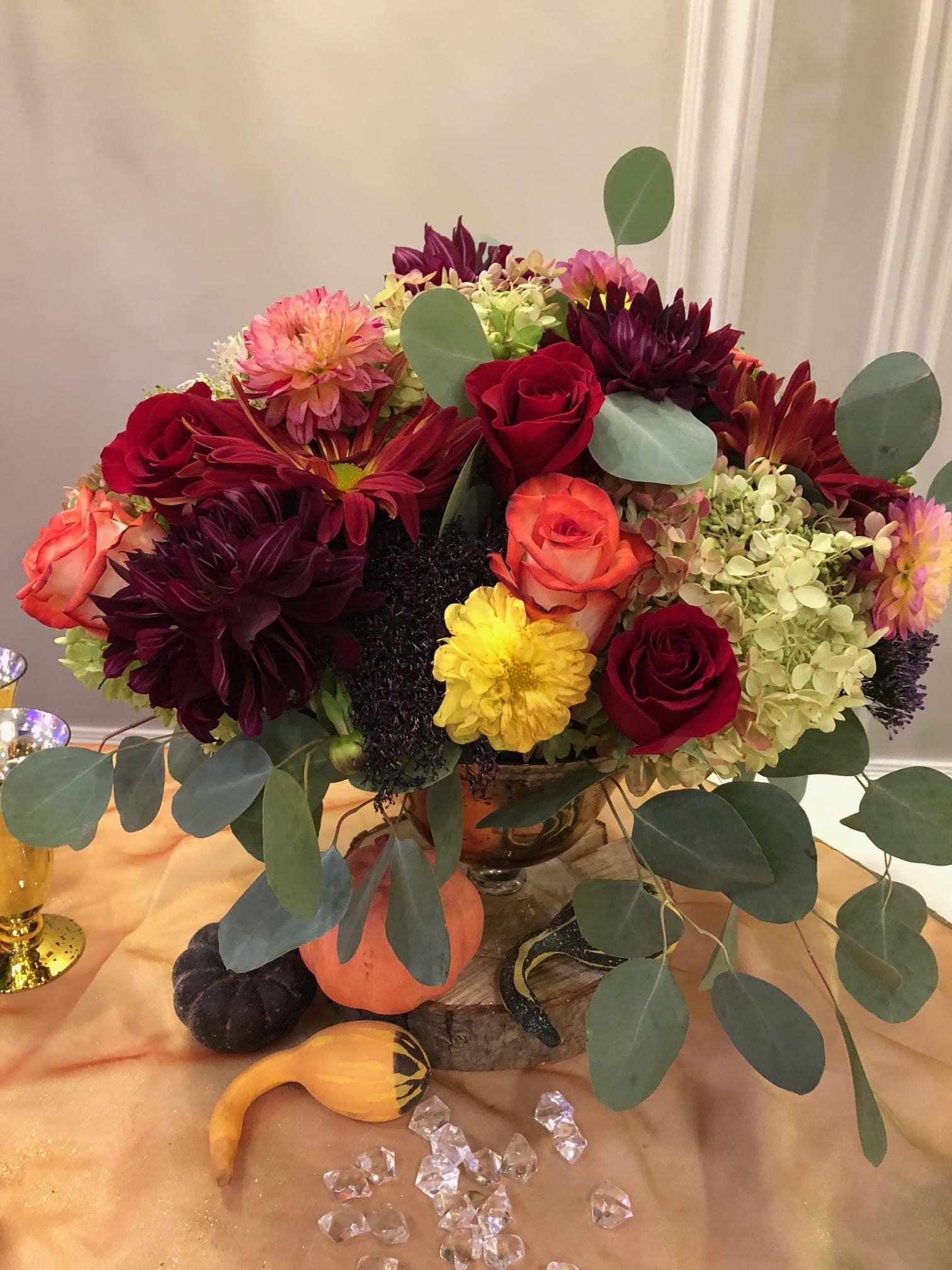 Fall in Love - This stunning arrangement of fall flowers in complimented by a beautiful mercury glad pedestal container. Elegant and seasonal. Simply lovely. 