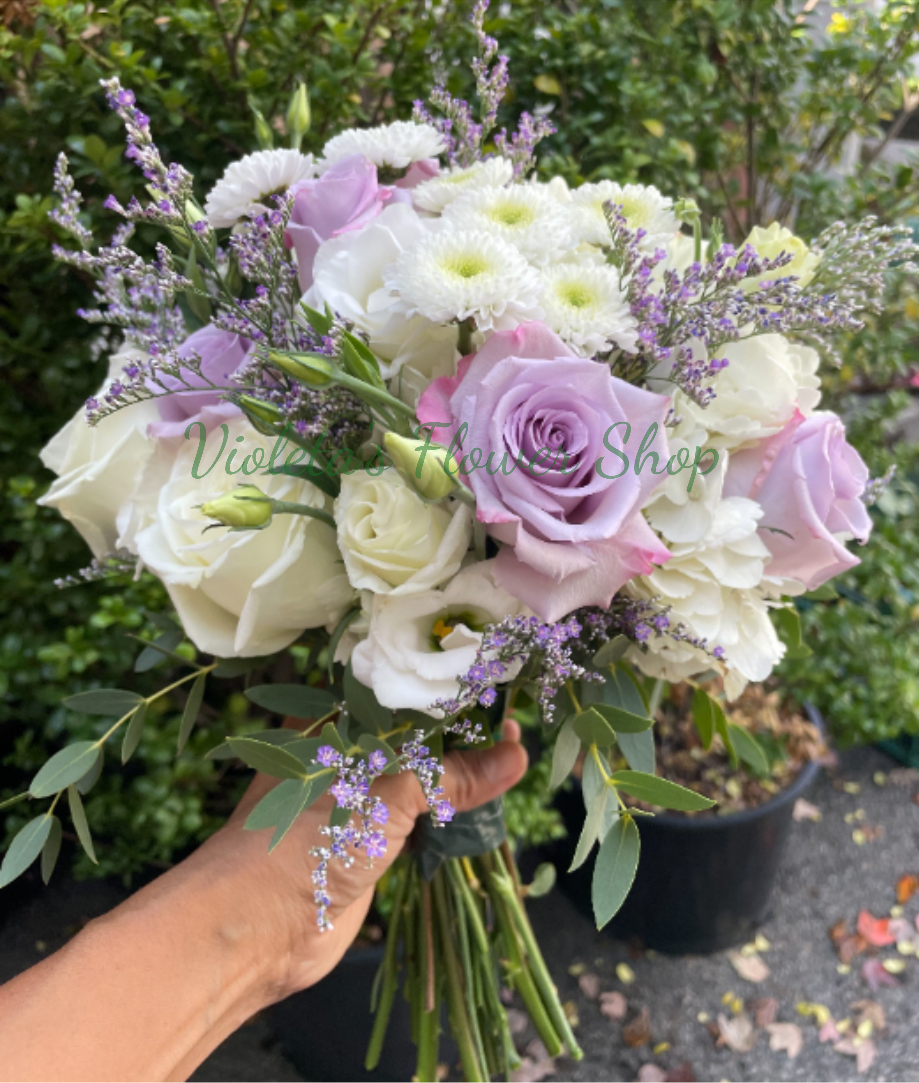 Lavender and White Wedding Bouquet - Soft lavender and crisp white roses create a dreamy focal point in this wedding bouquet, perfect for a bride seeking a romantic, garden-inspired look. The bouquet for weddings blends roses, delicate white daisy-like blooms and pale purple lisianthus or filler flowers to deliver a soft pastel palette of white, purple, and green that reads both timeless and gently modern.  Designed for ceremonies, anniversaries or an elegant rehearsal dinner, this bouquet makes the recipient feel cherished and softly celebrated. Care is simple: keep stems in water until the last moment and store in a cool place to preserve blooms; available as a hand-tied size suitable for carrying throughout your wedding day.