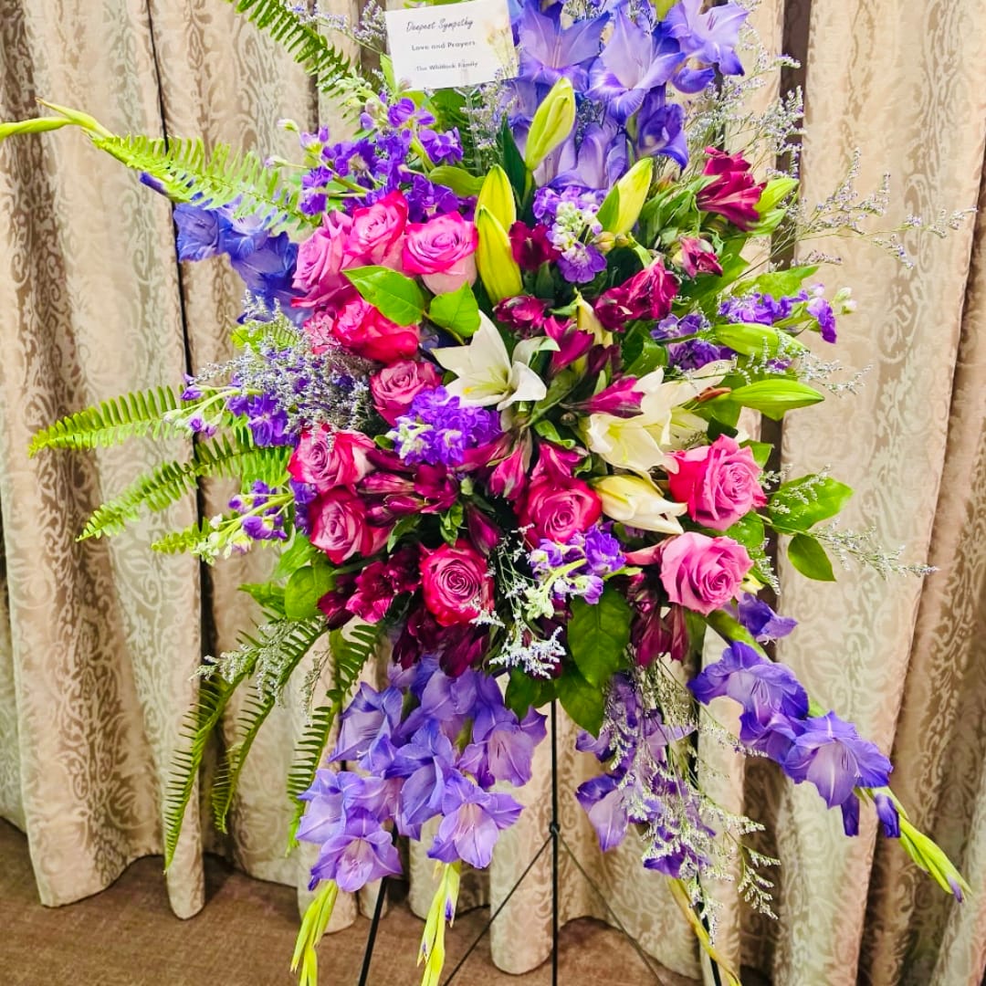 Large standing floral spray with pink roses, white lilies, and purple flowers