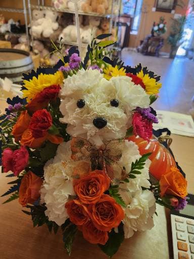 Flower arrangement shaped like a teddy bear with a bow