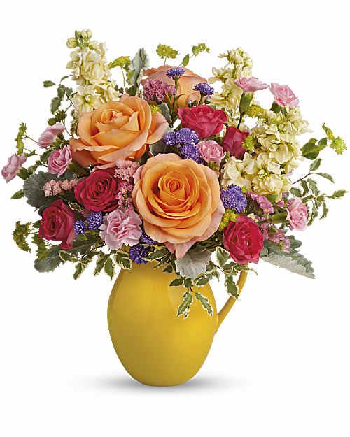 Be Bright Bouquet - Pour on the sunshine! Filled with radiant roses, this cheerful yellow pitcher sprinkles happiness on any occasion and makes a great food-safe addition to any home. Peach roses, hot pink spray roses, miniature pink carnations, light yellow stock, large purple monte cassino asters and pink sinuata statice are accented with bupleurum, pitta negra and dusty miller. Teleflora's Be Bright Bouquet is delivered in Teleflora's Sunny Day Pitcher. Orientation: All-Around 