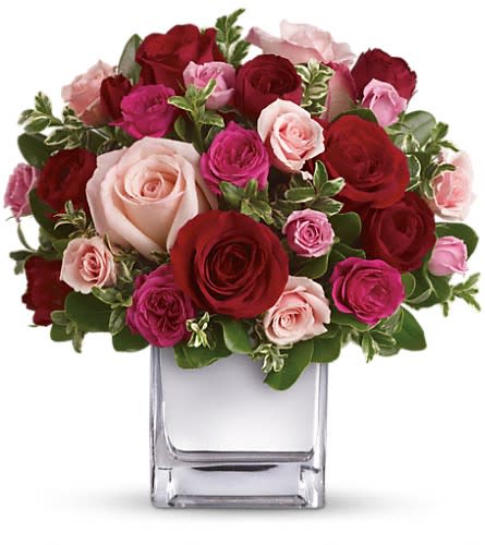 Teleflora's Love Medley Bouquet with Red Roses - Sing her a love song - with flowers. This lush loving rose arrangement tells her just how much you care. The stylish bouquet features large red and pink roses accented with smaller spray roses in shades of red and pinks. Delicate green oregonia and pittosporum add a fresh contrast and all comes arranged and delivered in our exclusive Mirrored Silver Cube vase.Approximately 10 1/2" W x 11" H Orientation: All-Around As Shown : T400-2ADeluxe : T400-2BPremium : T400-2C