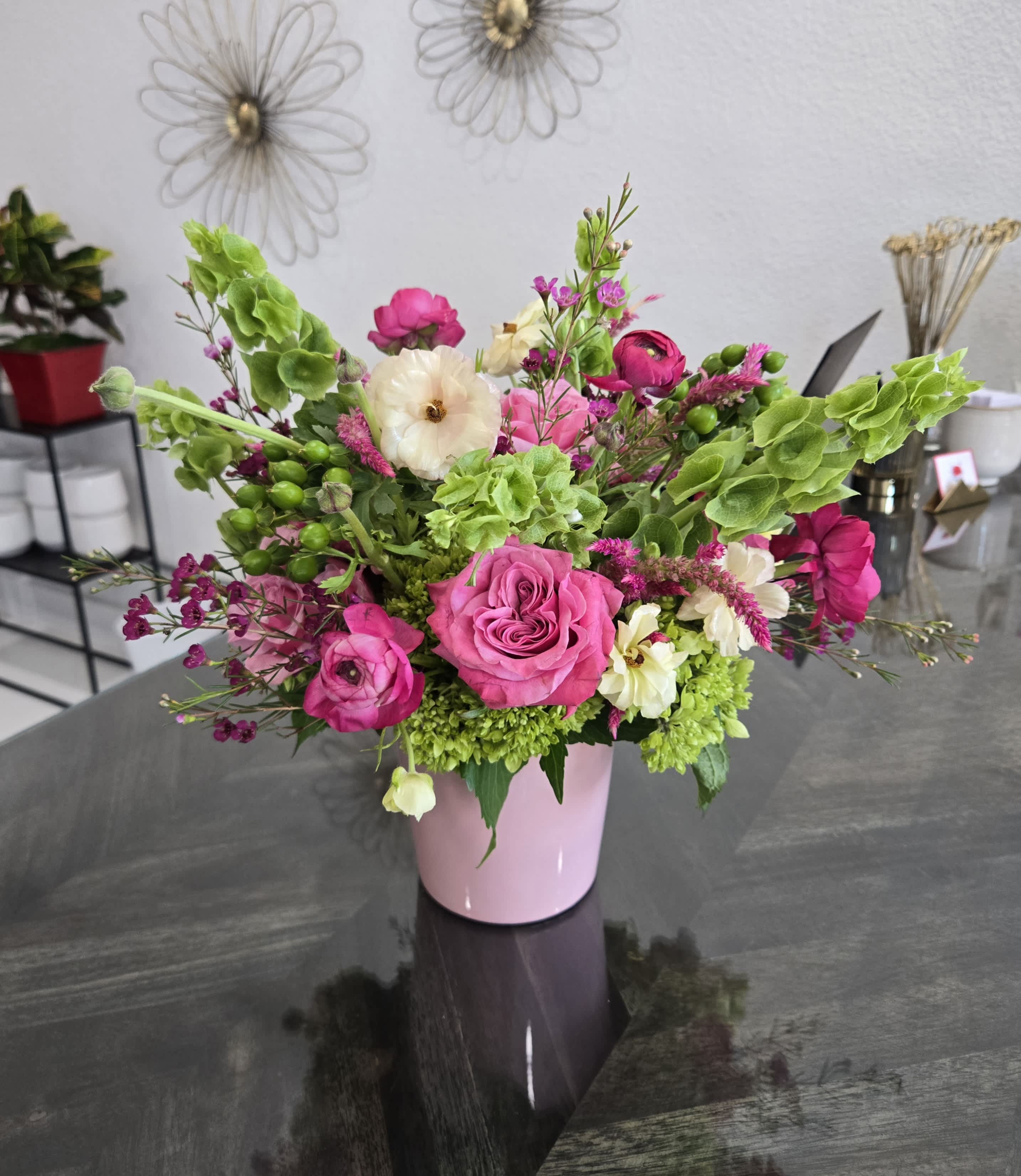 Pink and white floral arrangement in a pink vase