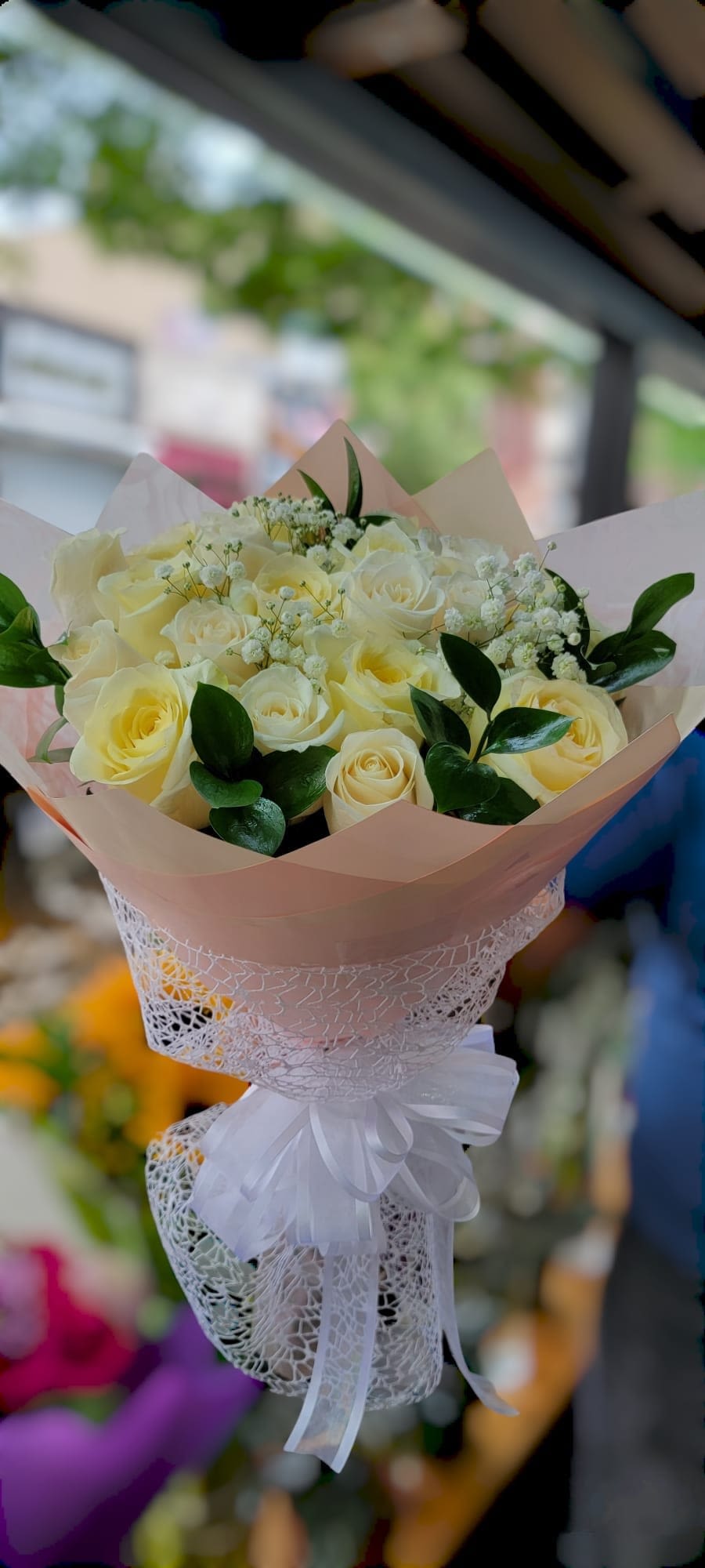 Bouquet of pale yellow roses with white filler flowers and a white ribbon