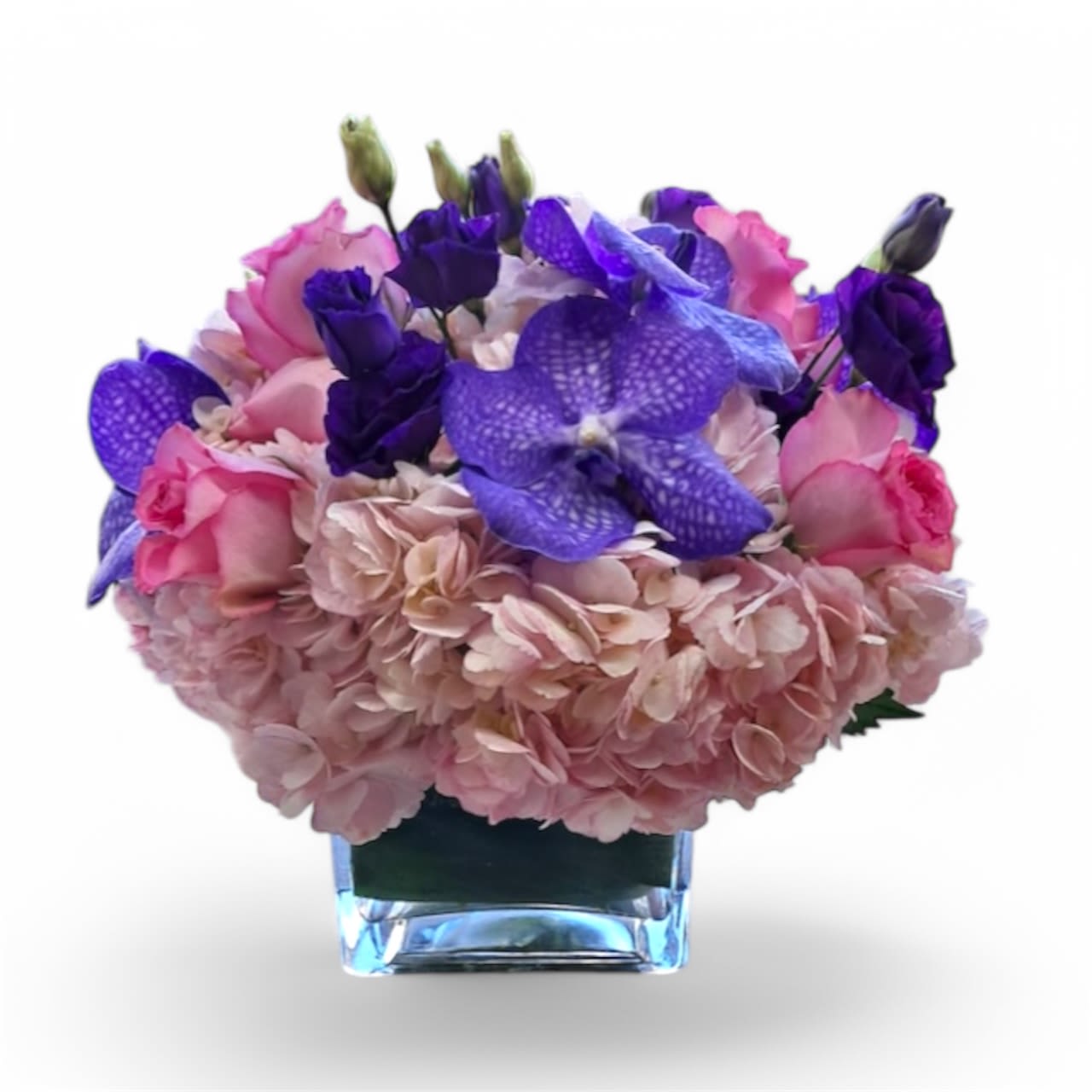 Pink and purple floral arrangement in a clear square vase