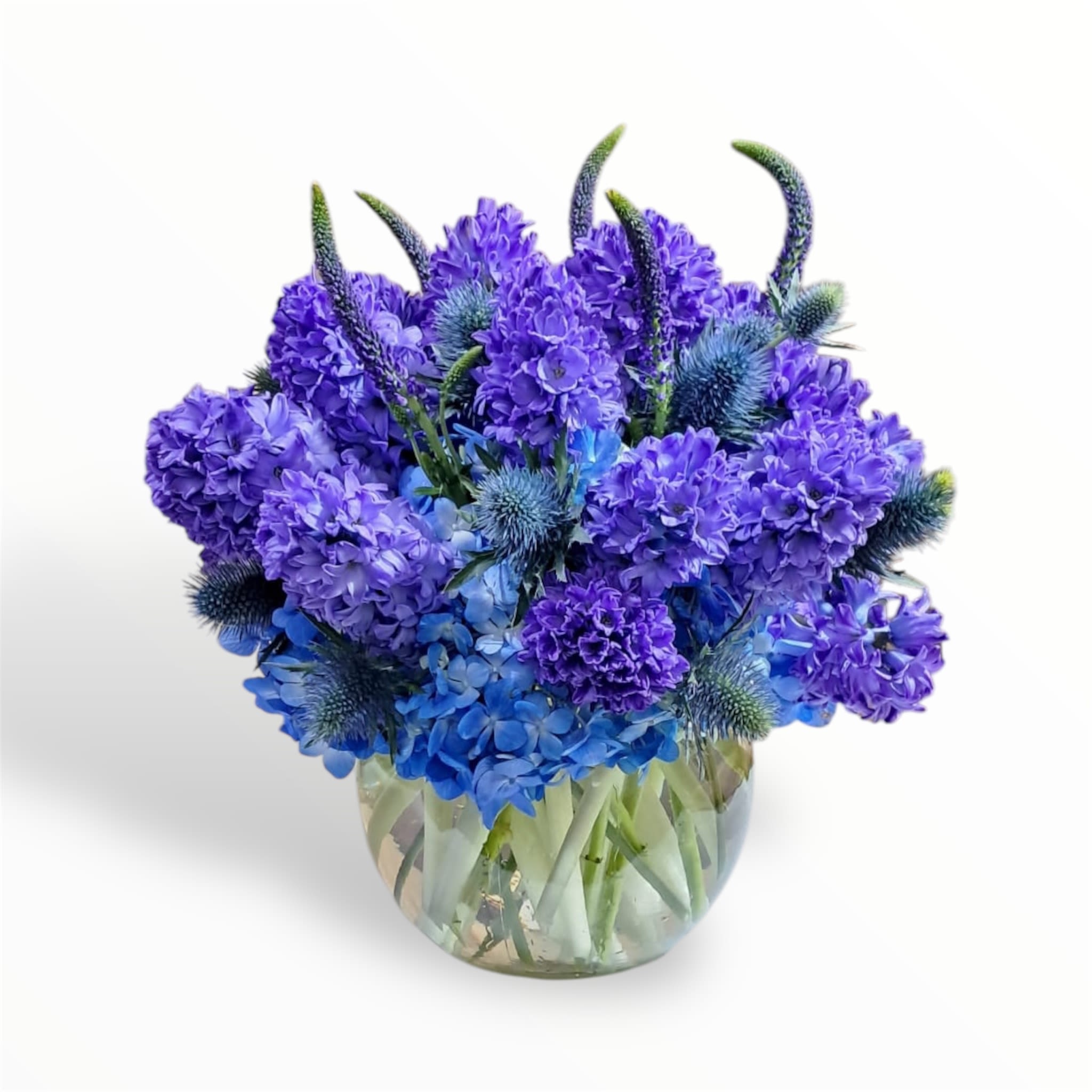 Blue and purple flower arrangement in a clear glass vase