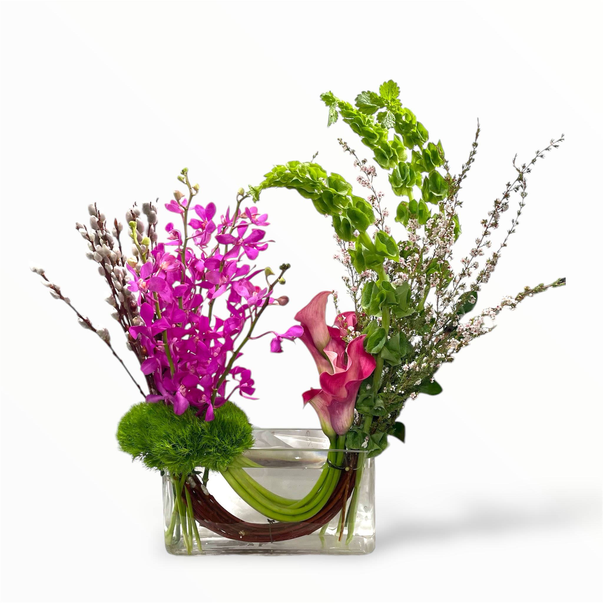 Pink orchids and calla lilies in a clear rectangular vase