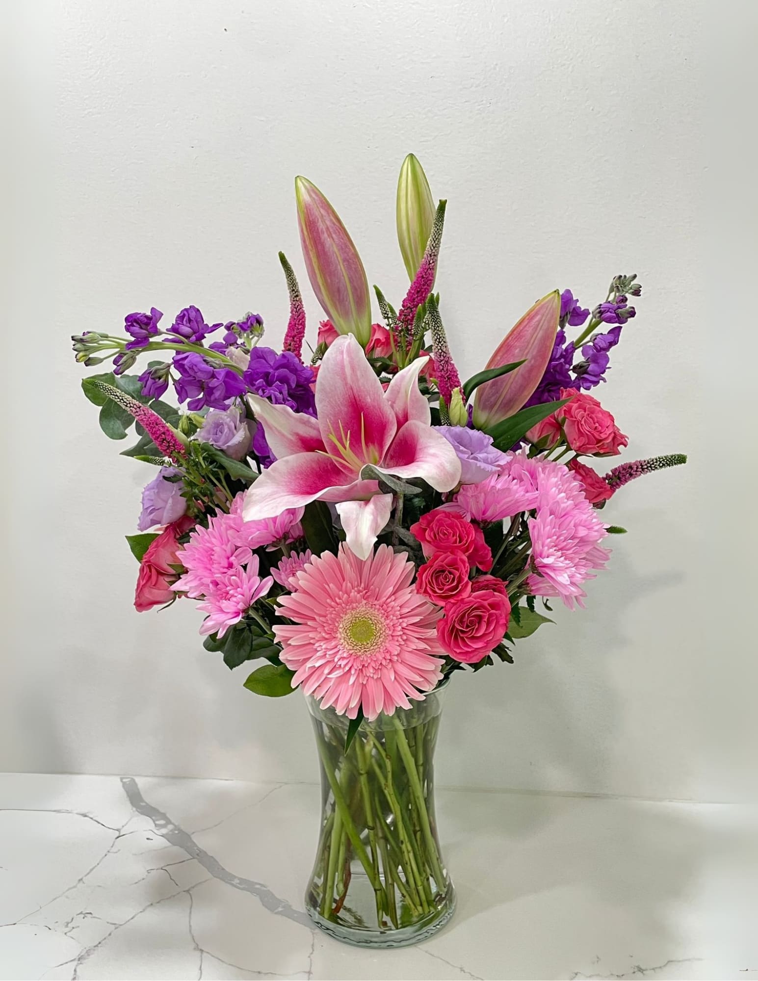Pink and purple mixed bouquet in a clear glass vase