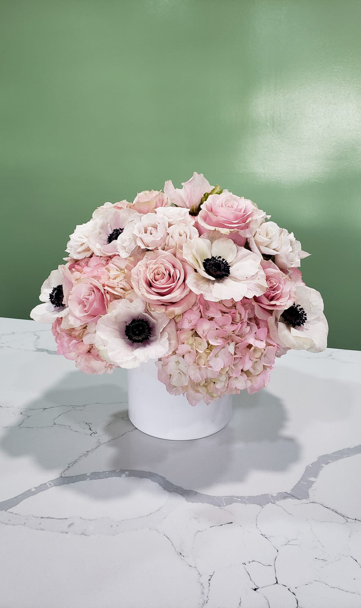 Pink and white floral arrangement in a white vase