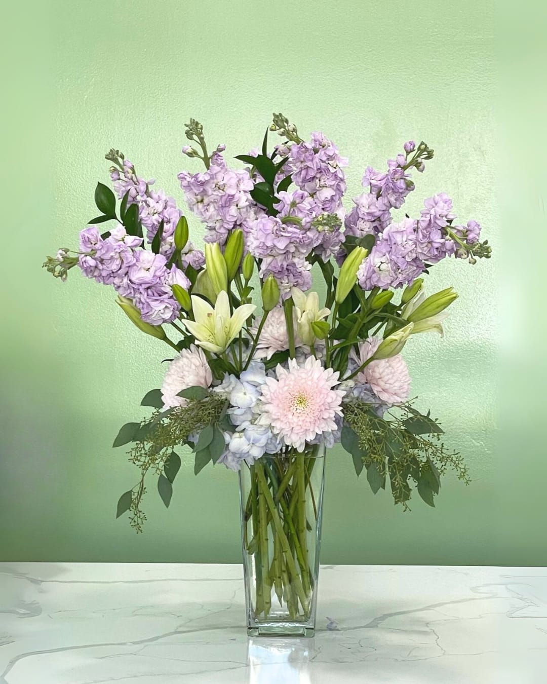 Lavender and white floral arrangement in a clear glass vase