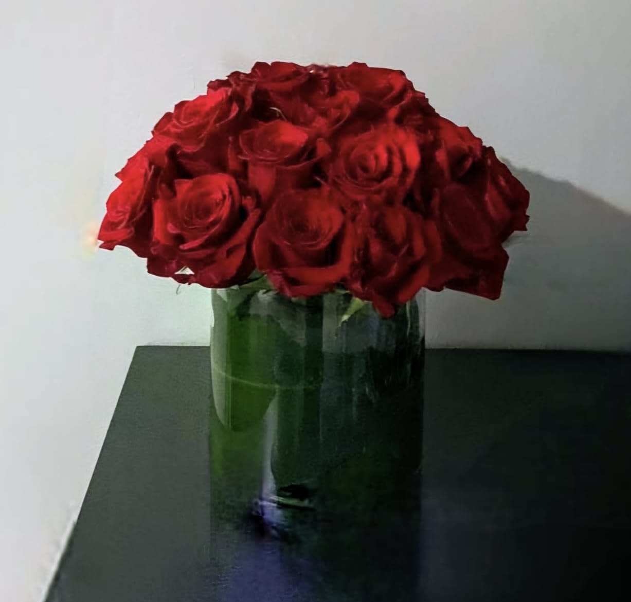 Red roses arranged in a clear glass vase