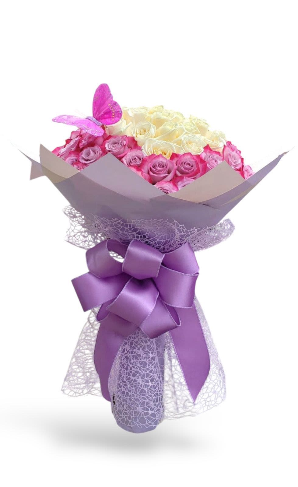 Bouquet of pink and cream roses with a purple butterfly and ribbon wrap