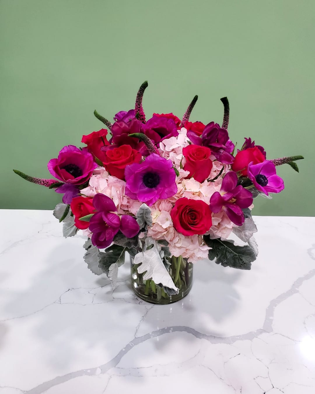 Pink and purple flower arrangement in a glass vase