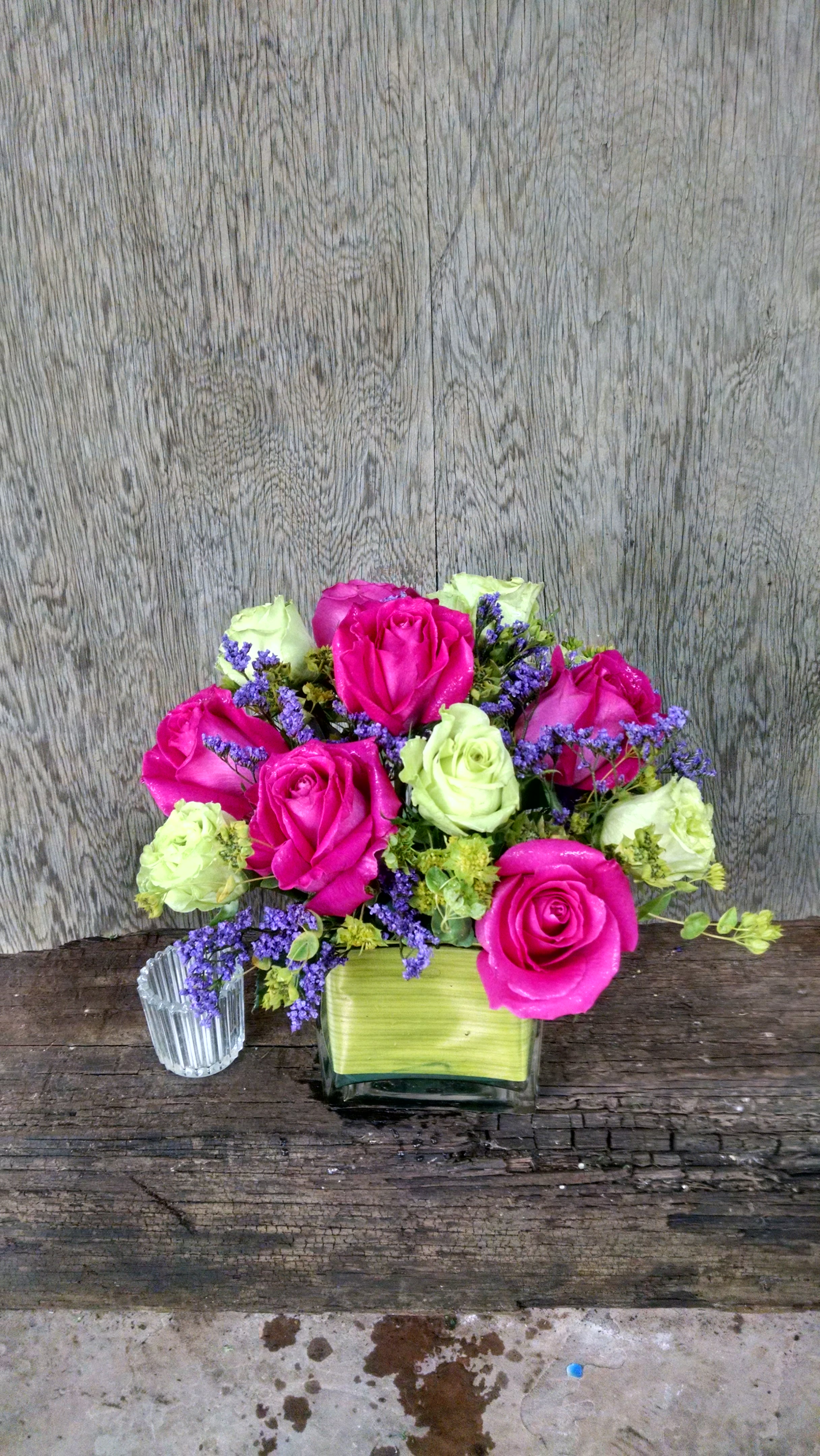 Pink and pale green roses in a square glass vase