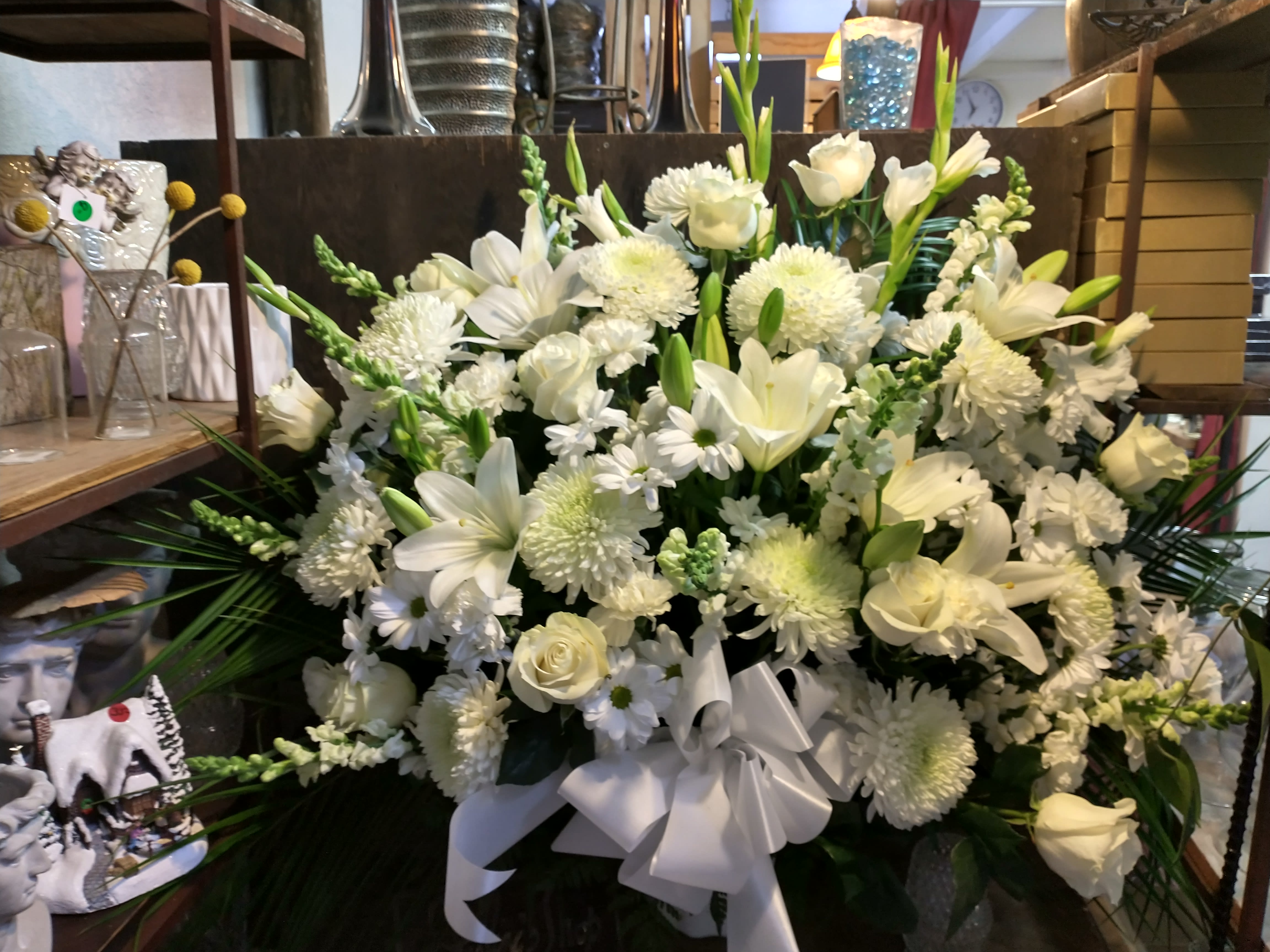 Large white floral arrangement with roses, lilies, and chrysanthemums