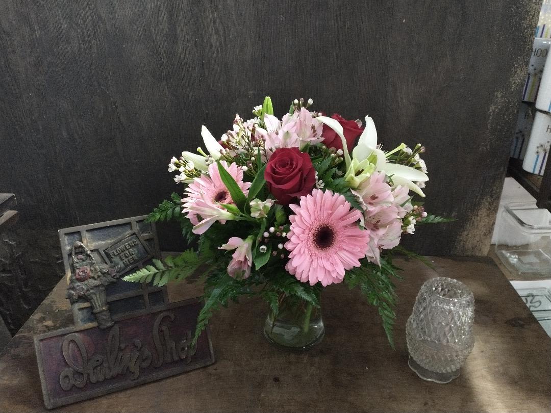 Pink and white mixed flower arrangement in a glass vase