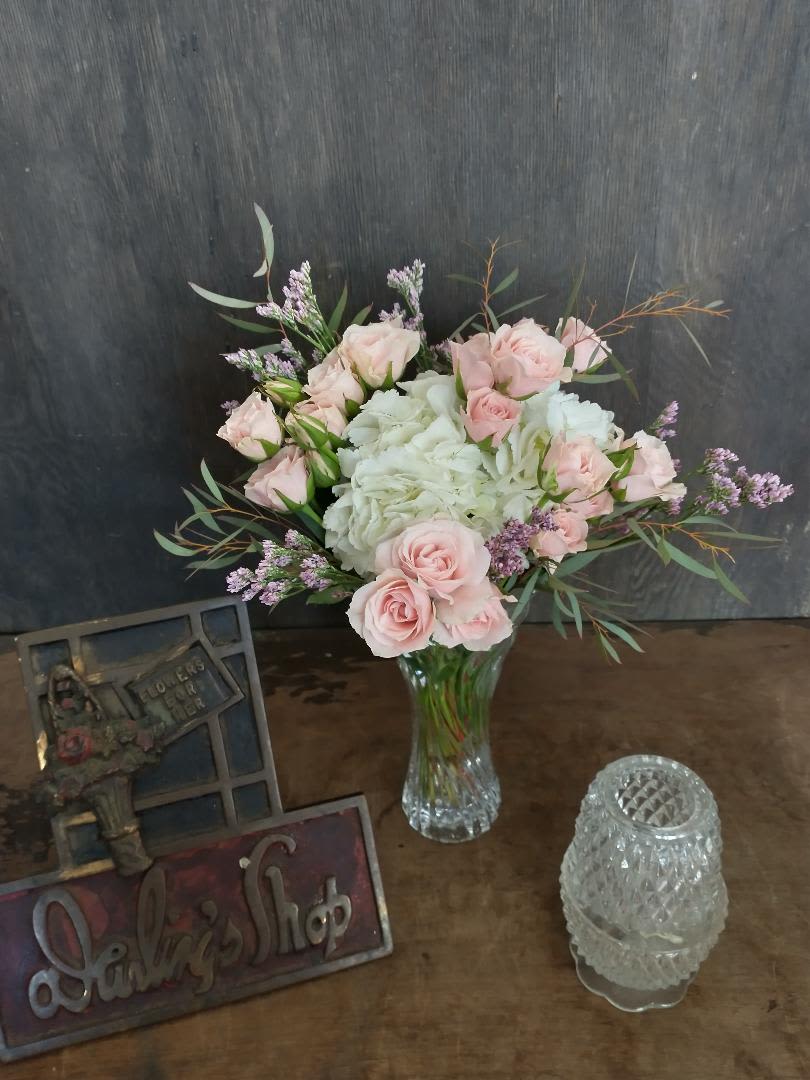 Pink roses and white hydrangeas in a clear glass vase