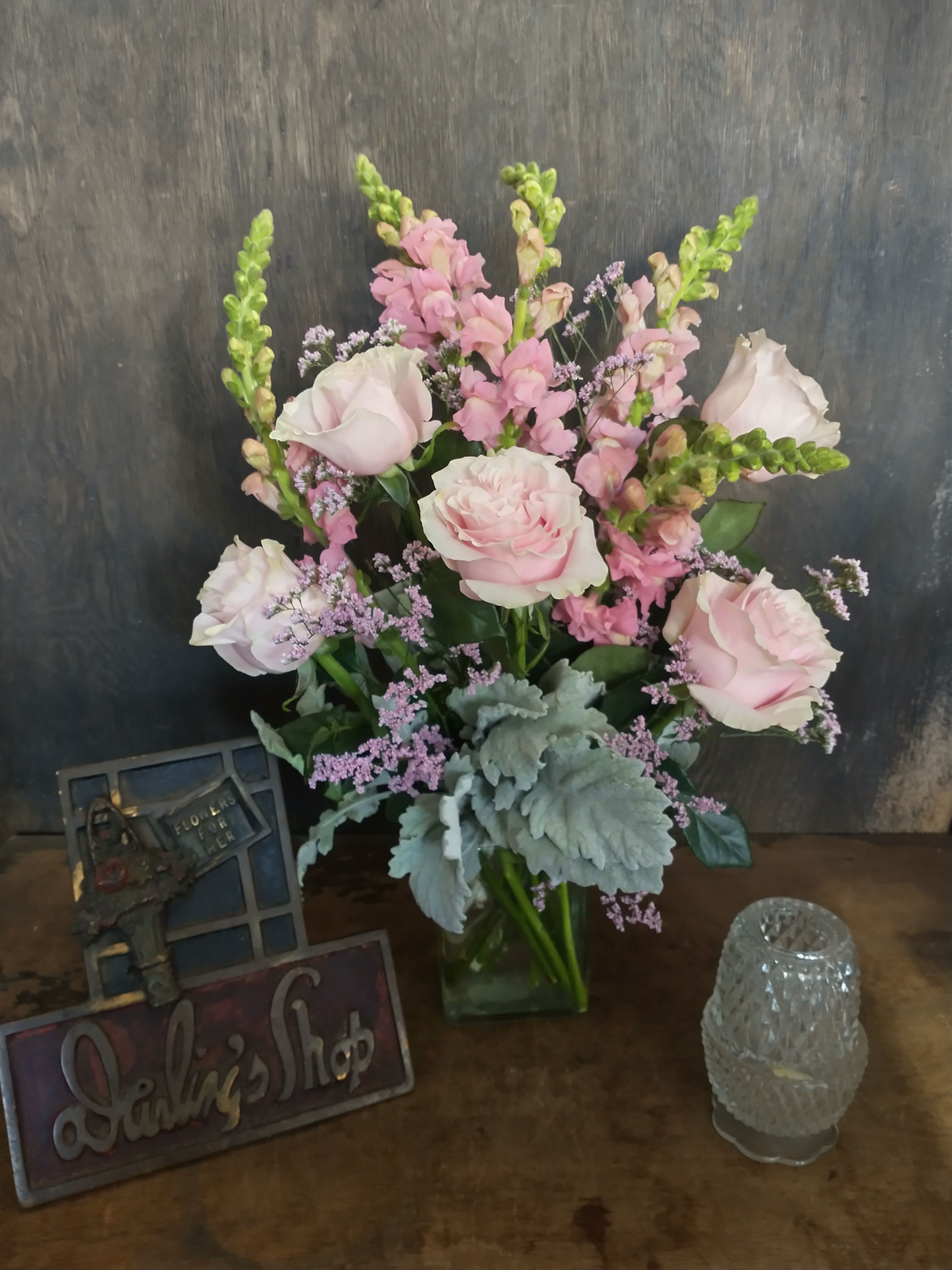 Pink roses and snapdragons arranged in a glass vase