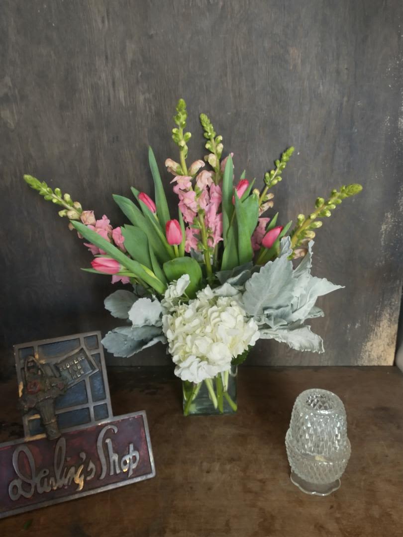 Pink tulips and white hydrangea in a clear glass vase
