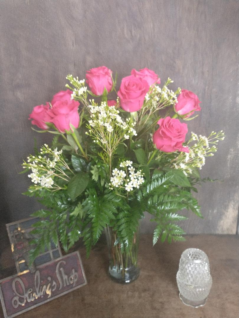Pink roses in a glass vase with white filler flowers