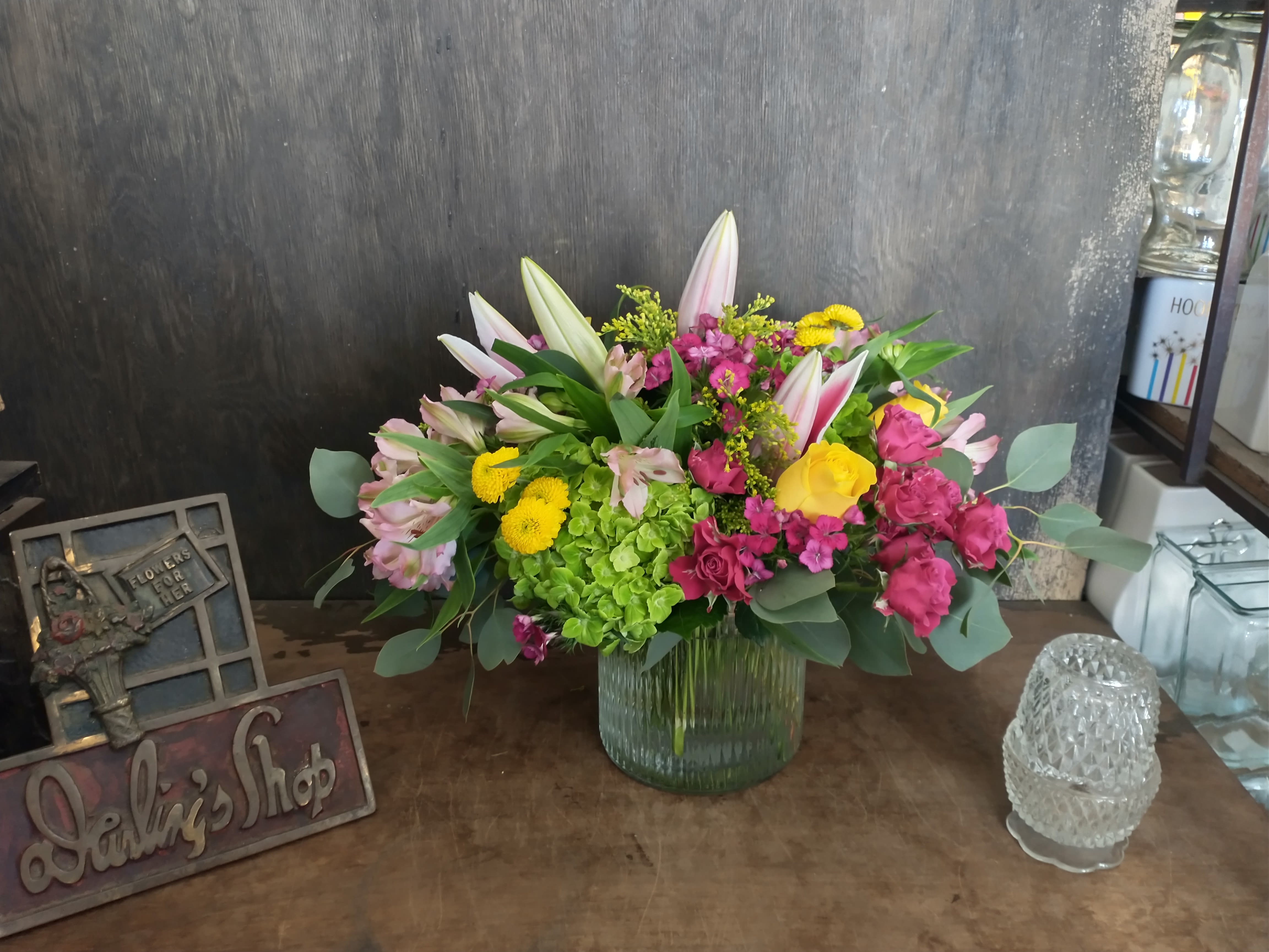 Mixed bouquet in a ribbed glass vase with pink, yellow, and white flowers