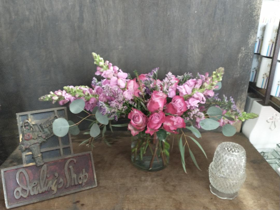 Pink rose and lavender flower arrangement in a glass vase