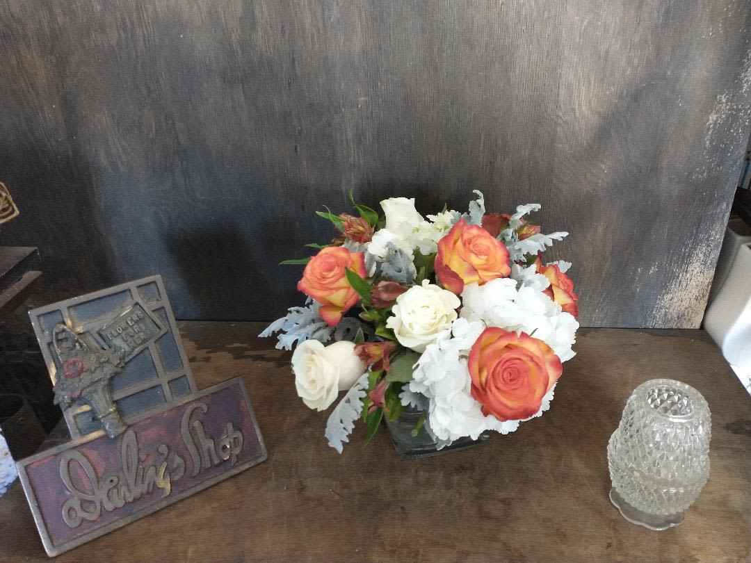 Bouquet of orange and white roses with white hydrangeas in a vase