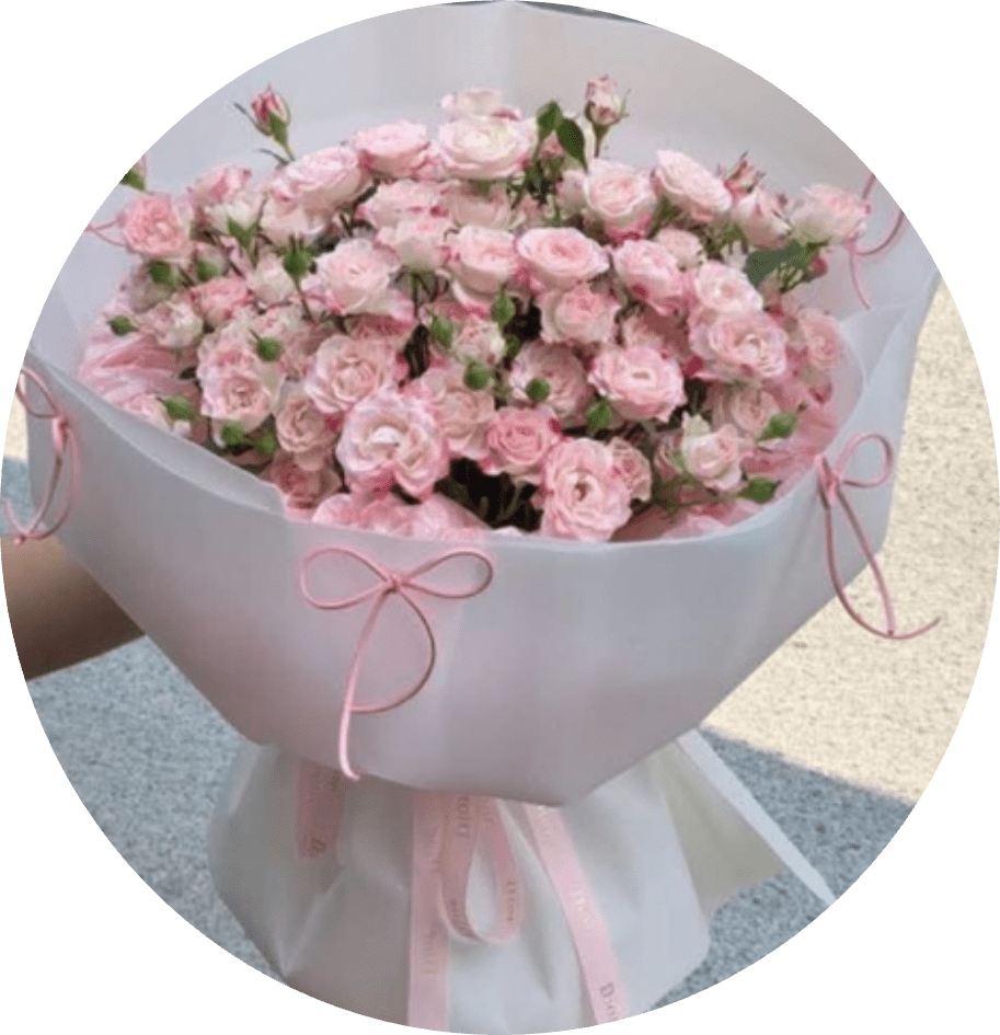 Princes Dammy MINI ROSES - A lush, rounded hand-tied bouquet of pale pink spray roses that reads as timeless romance-perfect as an anniversary roses bouquet, a birthday surprise, or a Mother's Day gift. Princes Dammy delivers a soft, feminine impression the moment it's seen: the recipient will feel cherished and celebrated by the cloud of delicate blooms and gentle pink tones.  Packed with many pale pink roses and spray roses in varying stages of bloom, this large arrangement creates a full, romantic silhouette. Each stem is gathered and wrapped in crisp white paper, finished with pink ribbon bows for a polished touch; the white paper wrap and delicate ribbon enhance the bouquet's soft palette of pink, white, and green without distracting from the flowers themselves.  Ideal for someone who appreciates classic, understated elegance-she'll feel truly seen when this bouquet arrives on her special day or as a spontaneous romantic gesture. Size and styling make it easy to place in a vase at home; to keep the blossoms looking their best, trim stems and refresh water daily after delivery.
