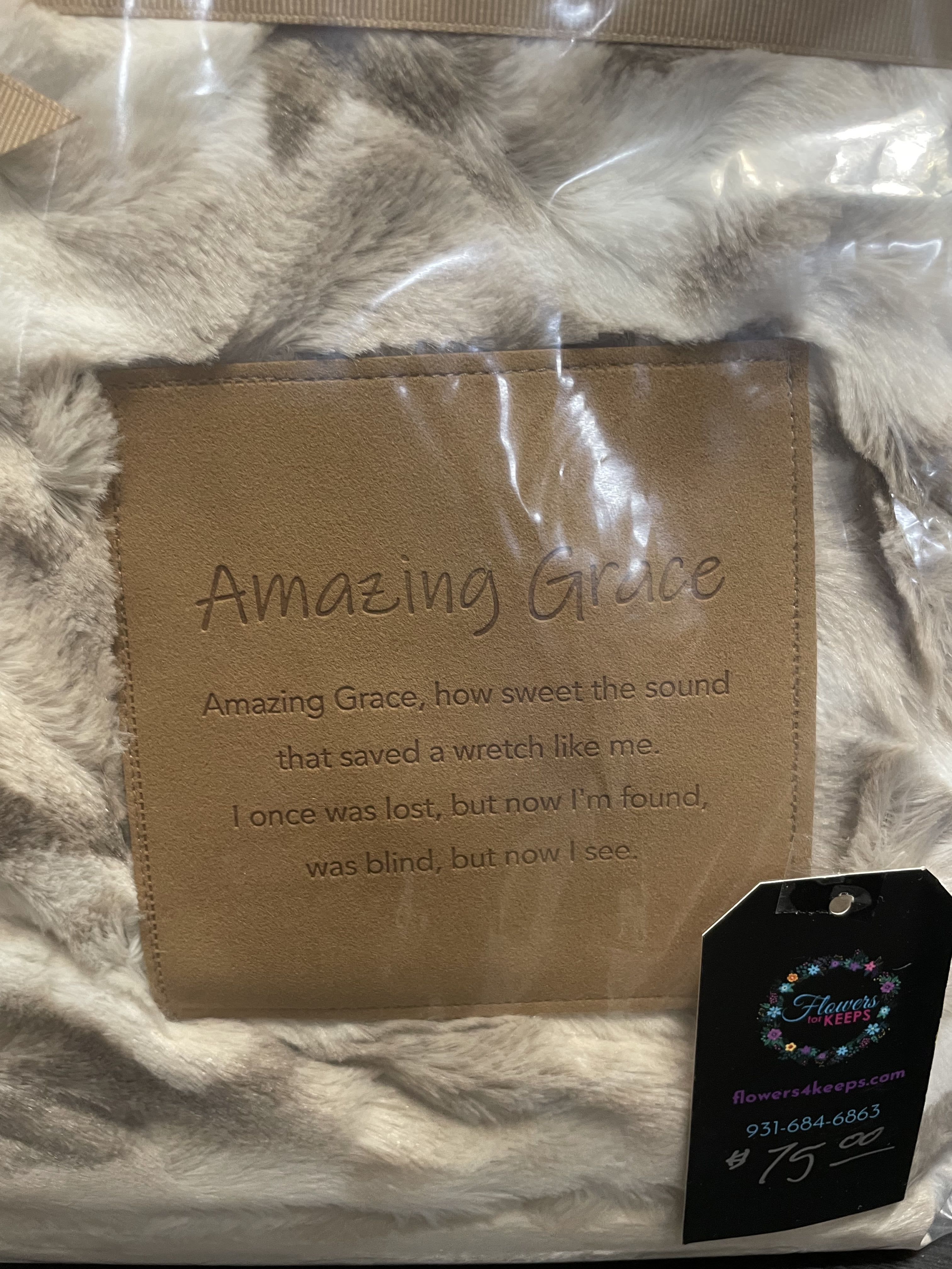 Faux fur throw with a tan embroidered panel reading Amazing Grace