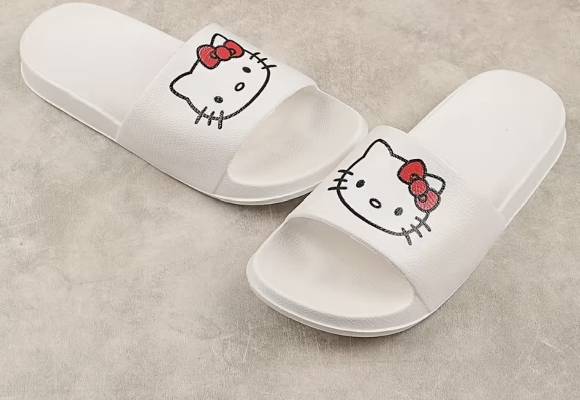 Pair of white slide sandals with Hello Kitty faces on the straps