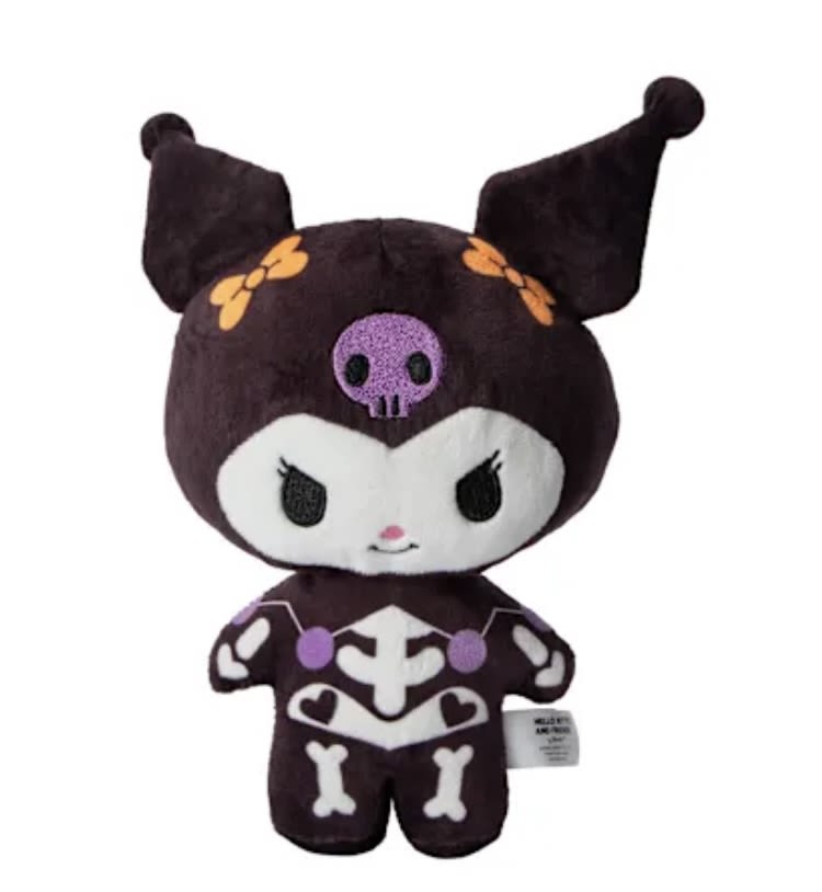 Plush character toy in dark purple and white with skull and bone details
