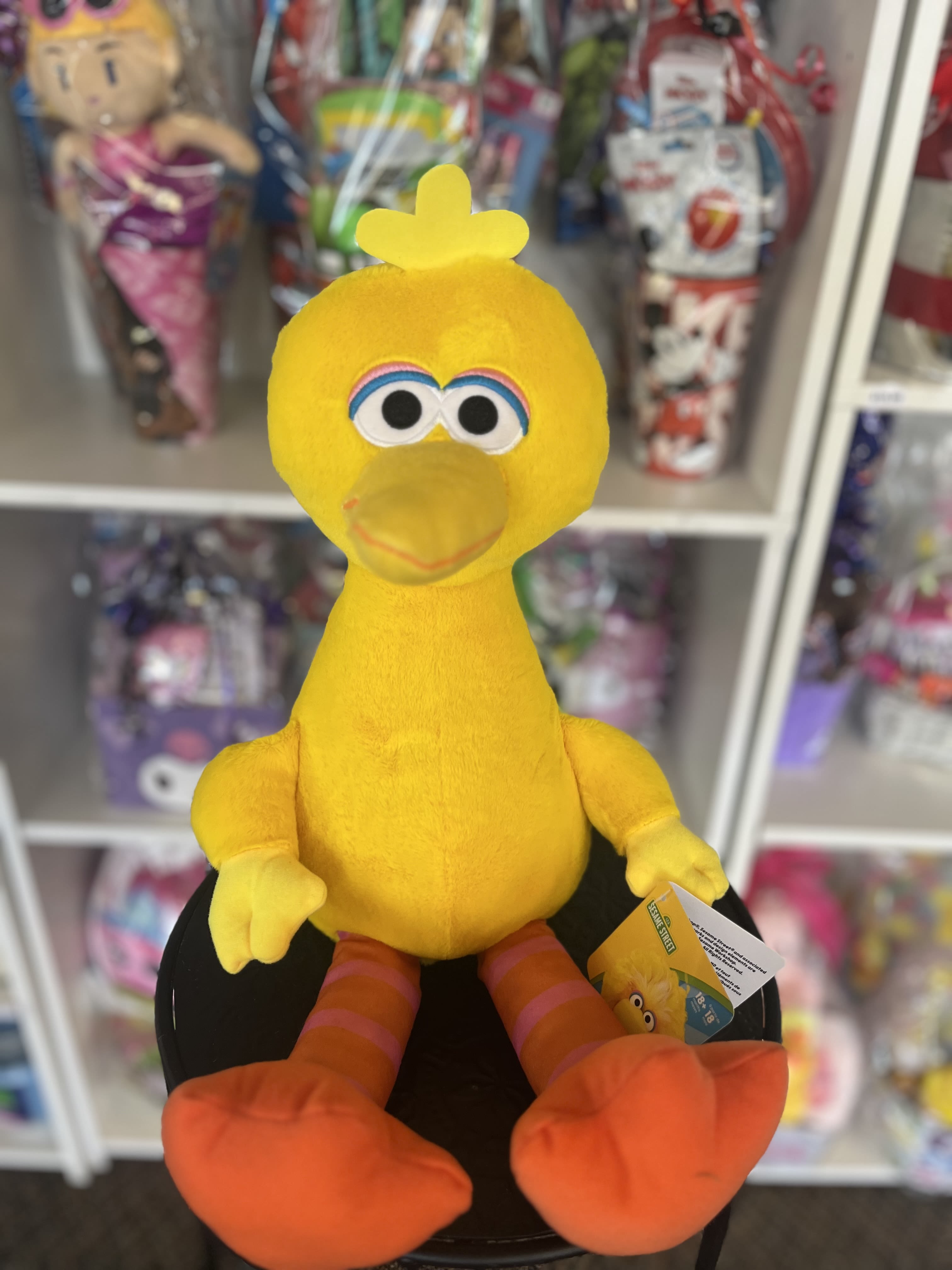 Yellow plush bird toy with orange feet and a tag