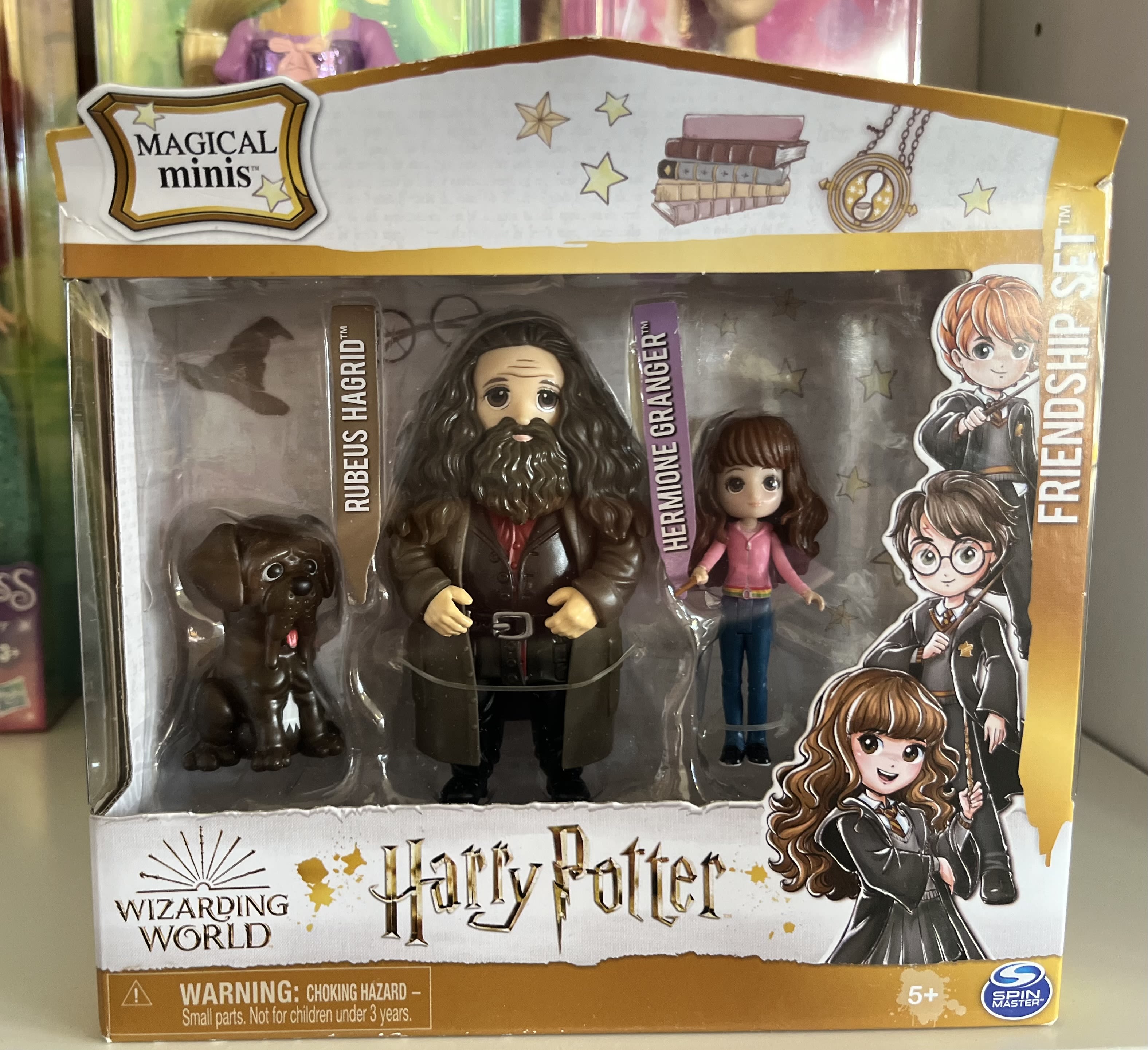 Harry Potter toy set with figures of Hagrid, Hermione, and a dog in a box