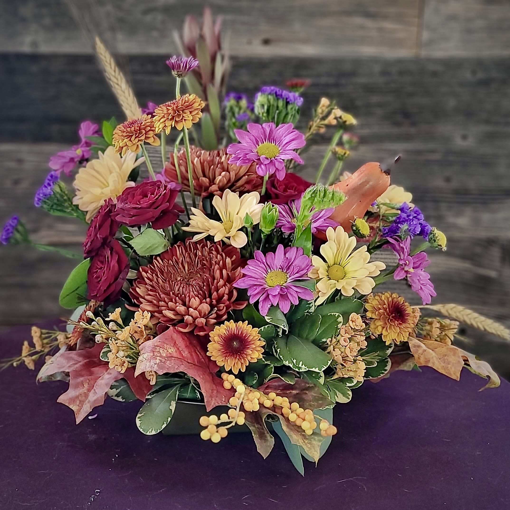 Autumn Orchard - A lush medley of fall blossoms in warm, rustic tones, accented with wheat, foliage, and seasonal textures. Designed to evoke the charm of the countryside, this arrangement makes a stunning centerpiece for welcoming guests and celebrating the beauty of autumn. 
