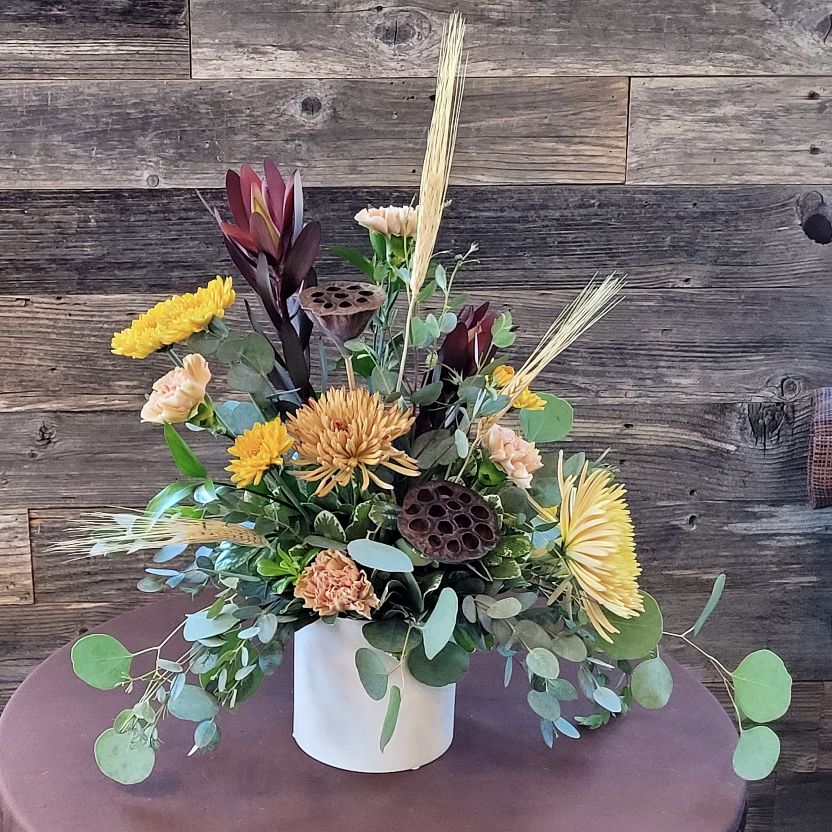 Amber Fields - Celebrate the season with a rustic mix of golden blooms, wheat, and earthy accents. Perfect for gatherings, gifting, or simply brightening the home. 