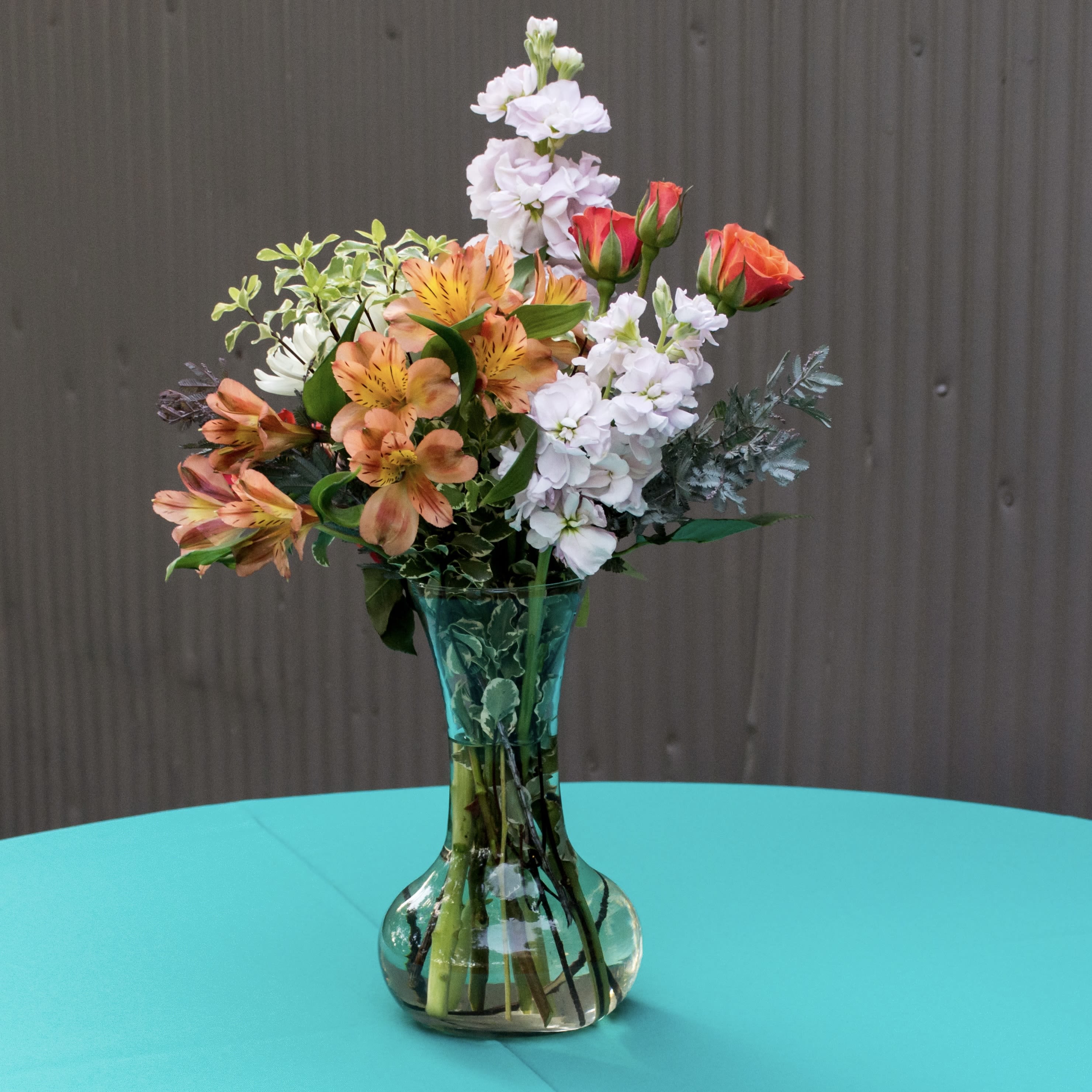 Mixed bouquet of orange and white flowers in a glass vase