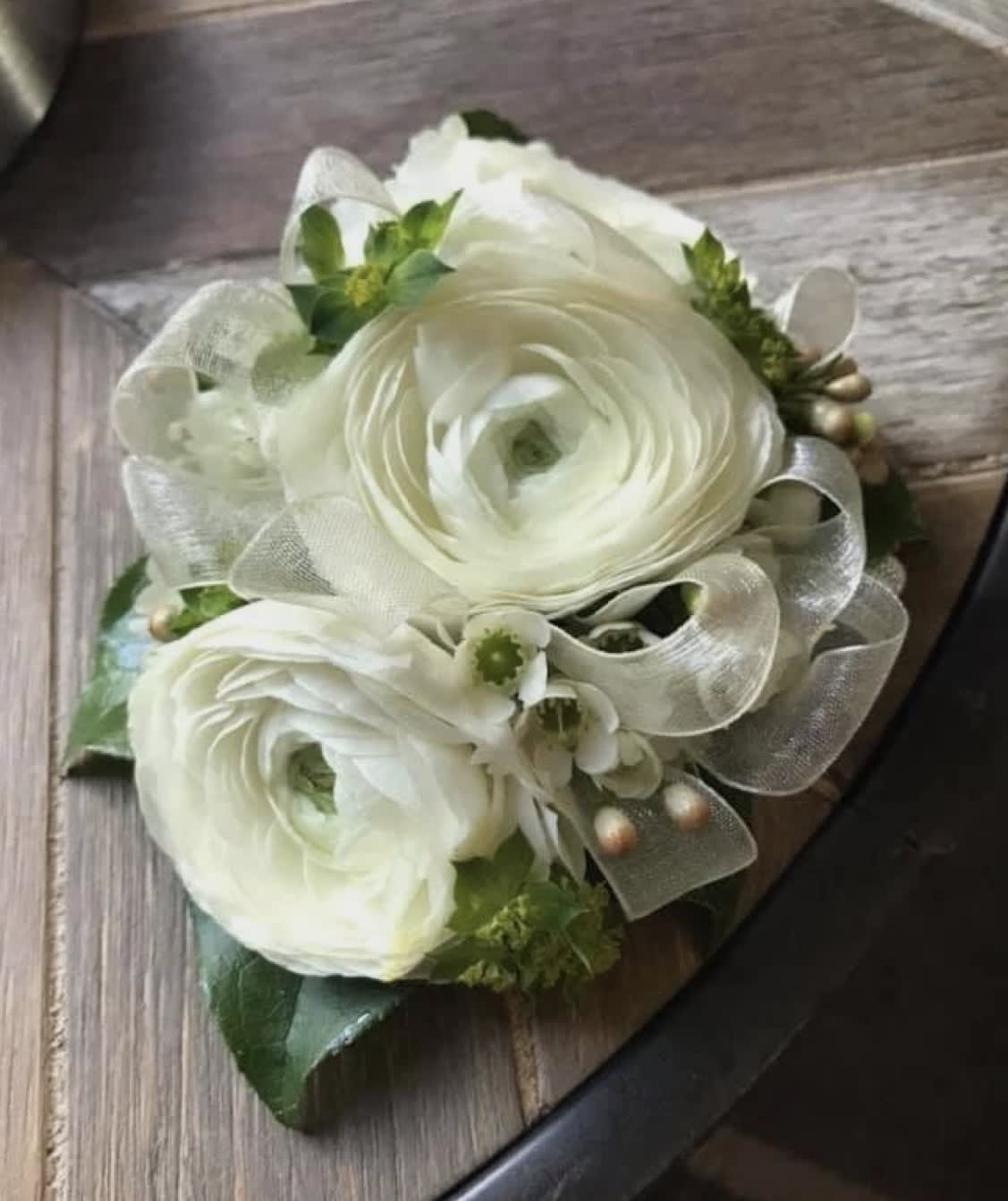 White ranunculus bouquet with silver ribbon and small green accents