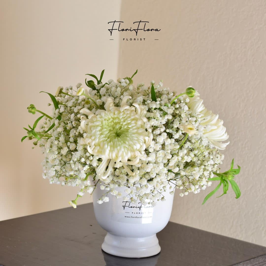 Pure Radiance - Let your space shine with the breathtaking beauty of Pure Radiance—an exquisite floral arrangement designed to captivate and inspire. Featuring the delicate elegance of Baby's Breath paired with the striking sophistication of Spider Mums, this arrangement is a true vision of purity and grace. The soft, airy texture of Baby's Breath brings a light, whimsical touch, while the bold, intricate Spider Mums make a statement of refined luxury. Whether you're celebrating a special occasion or simply elevating your home, Pure Radiance effortlessly adds a touch of timeless beauty and a radiant glow to any setting.  Experience the magic of white flowers in full bloom—where elegance meets luminosity.